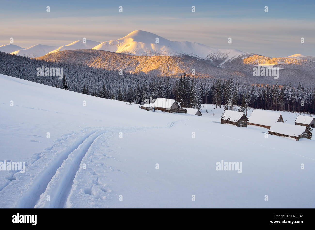 Morgen Landschaft in den Bergen. Ski Spuren im Schnee. Holz- Häuser im Dorf der Hirten. Karpaten, Ukraine Stockfoto