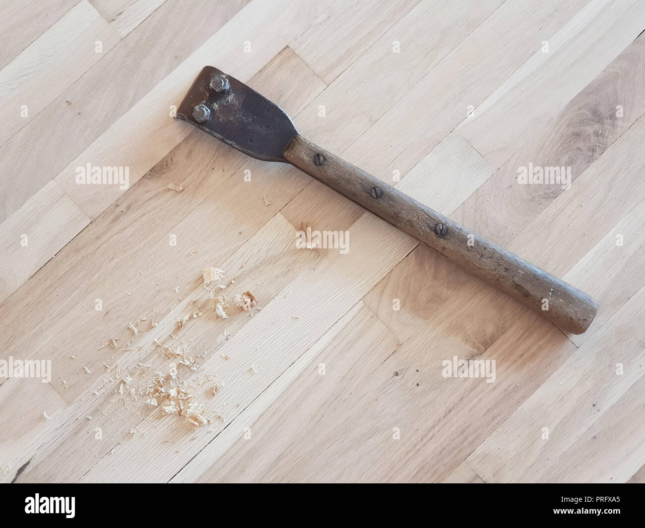 Hand Schaber und Holzspänen auf einer Eiche Parkettboden im Prozess der Wiederherstellung. Stockfoto