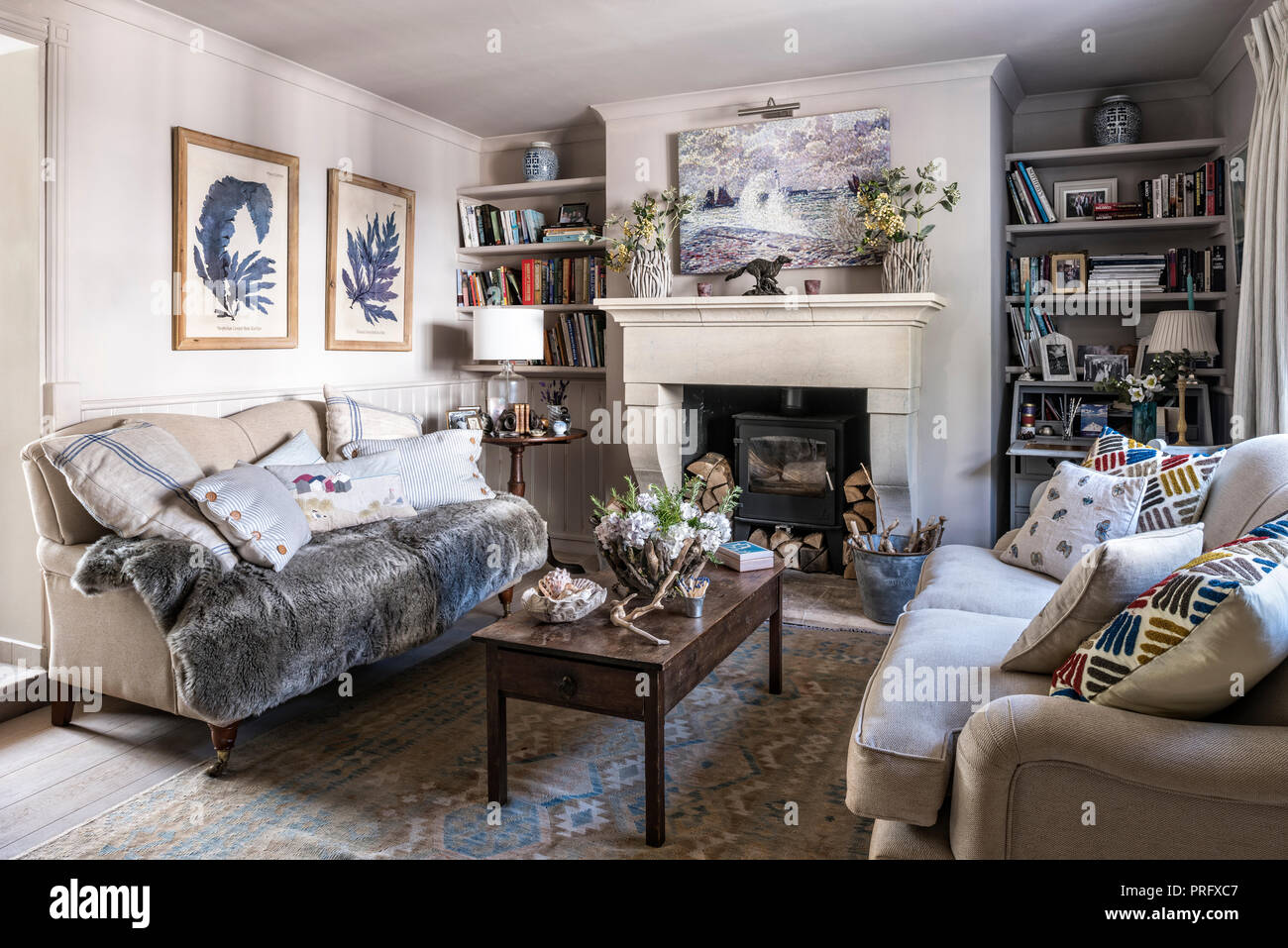 Antike Couchtisch mit Sofas und Kunstwerke in Wohnzimmer, Devon Cottage Stockfoto