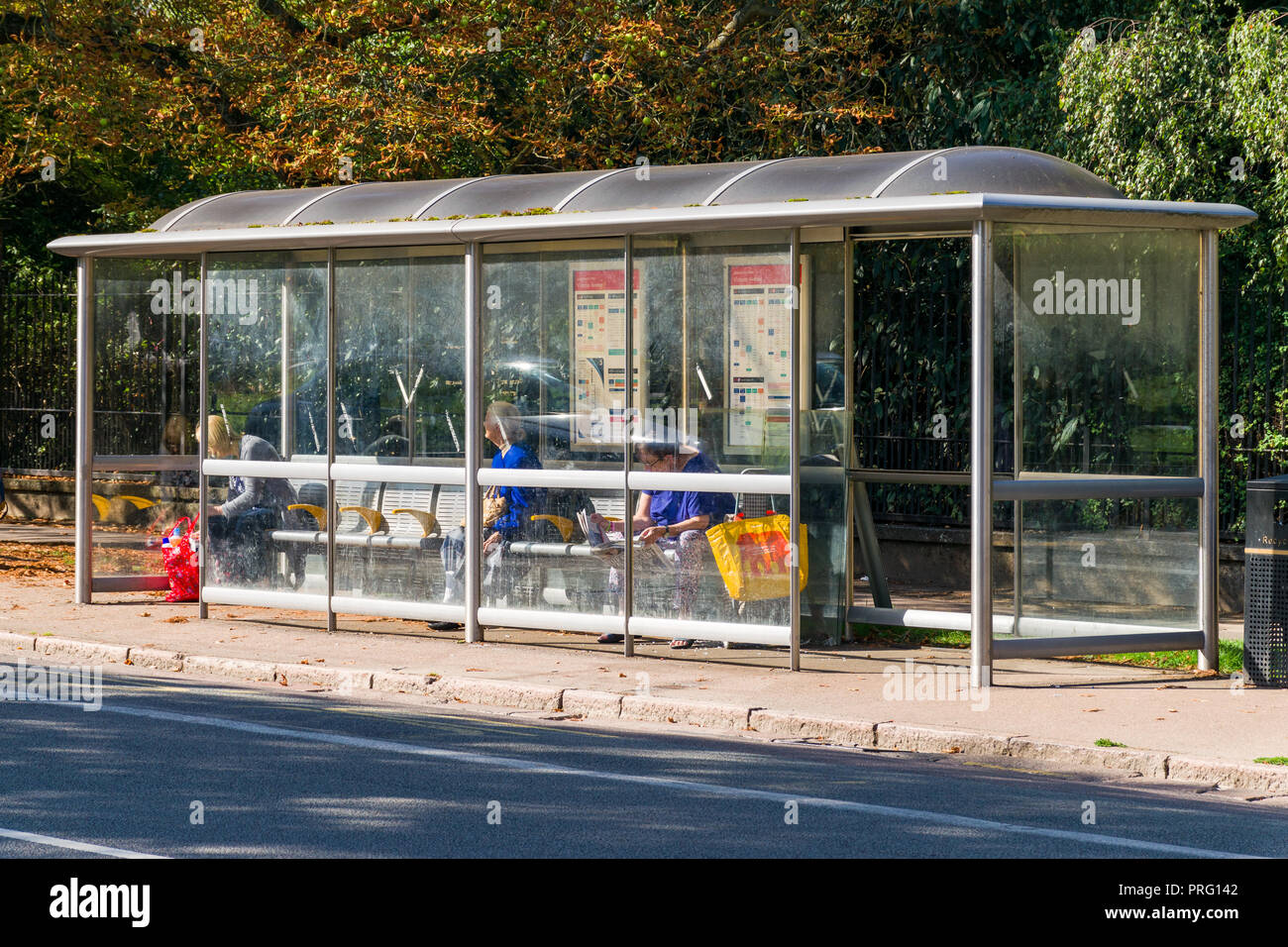 Frauen sassen in einer überdachten Bushaltestelle auf der Victoria Avenue warten auf einen Bus, Cambridge, Großbritannien Stockfoto