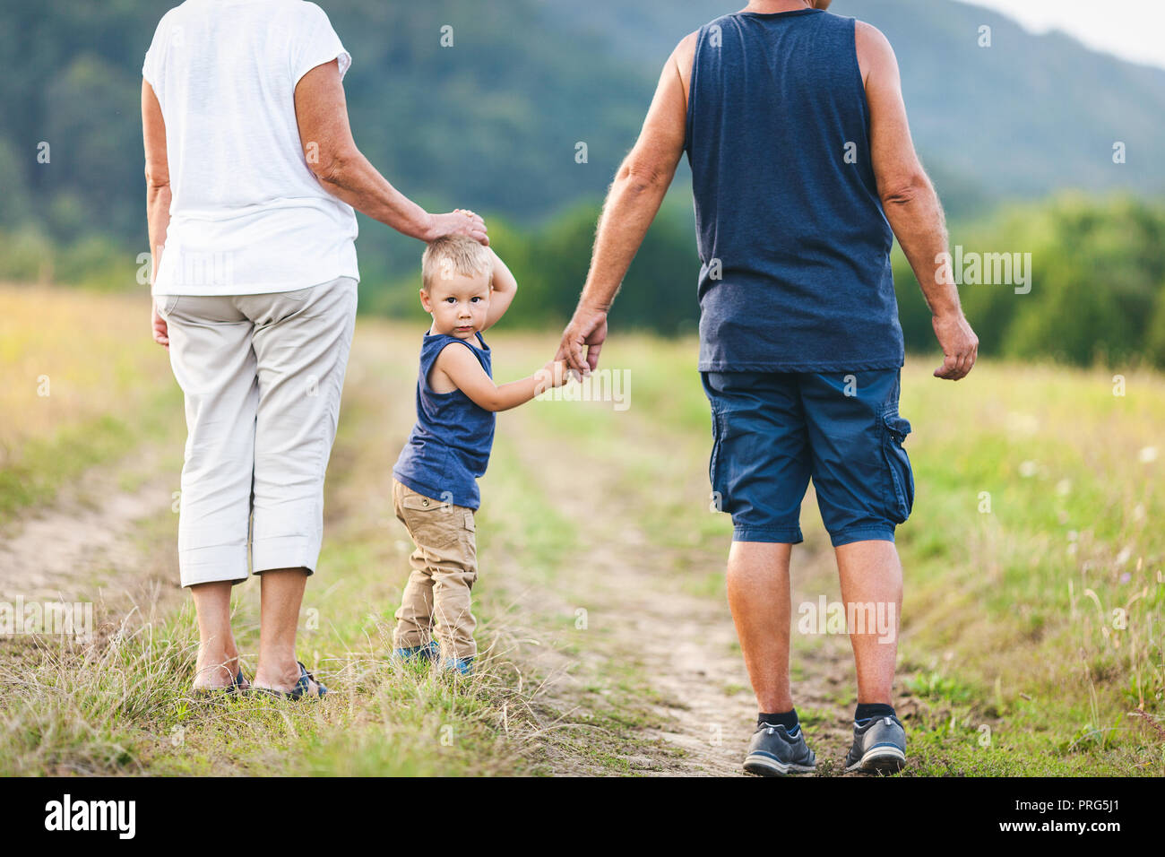 Glückliche Großeltern auf einem Spaziergang ausserhalb mit ihren Enkel Stockfoto