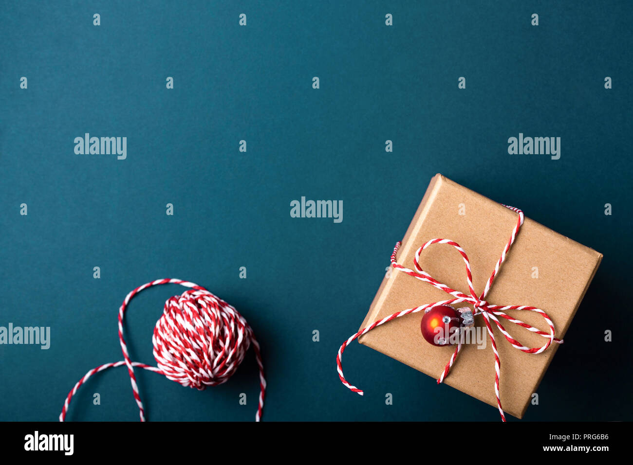 Geschenkbox in braunes Packpapier eingewickelt und gebunden mit Zuckerstange Weihnachten Seil auf dunkelblauen Hintergrund. Urlaub Konzept, Ansicht von oben. Stockfoto