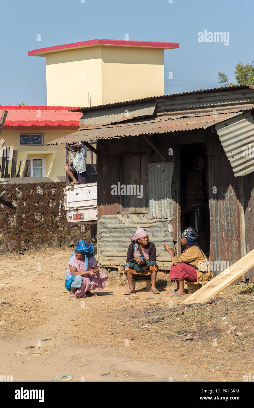 Die Menschen reden außerhalb von Haus aus Wellblech, Meghalaya, Indien Stockfoto