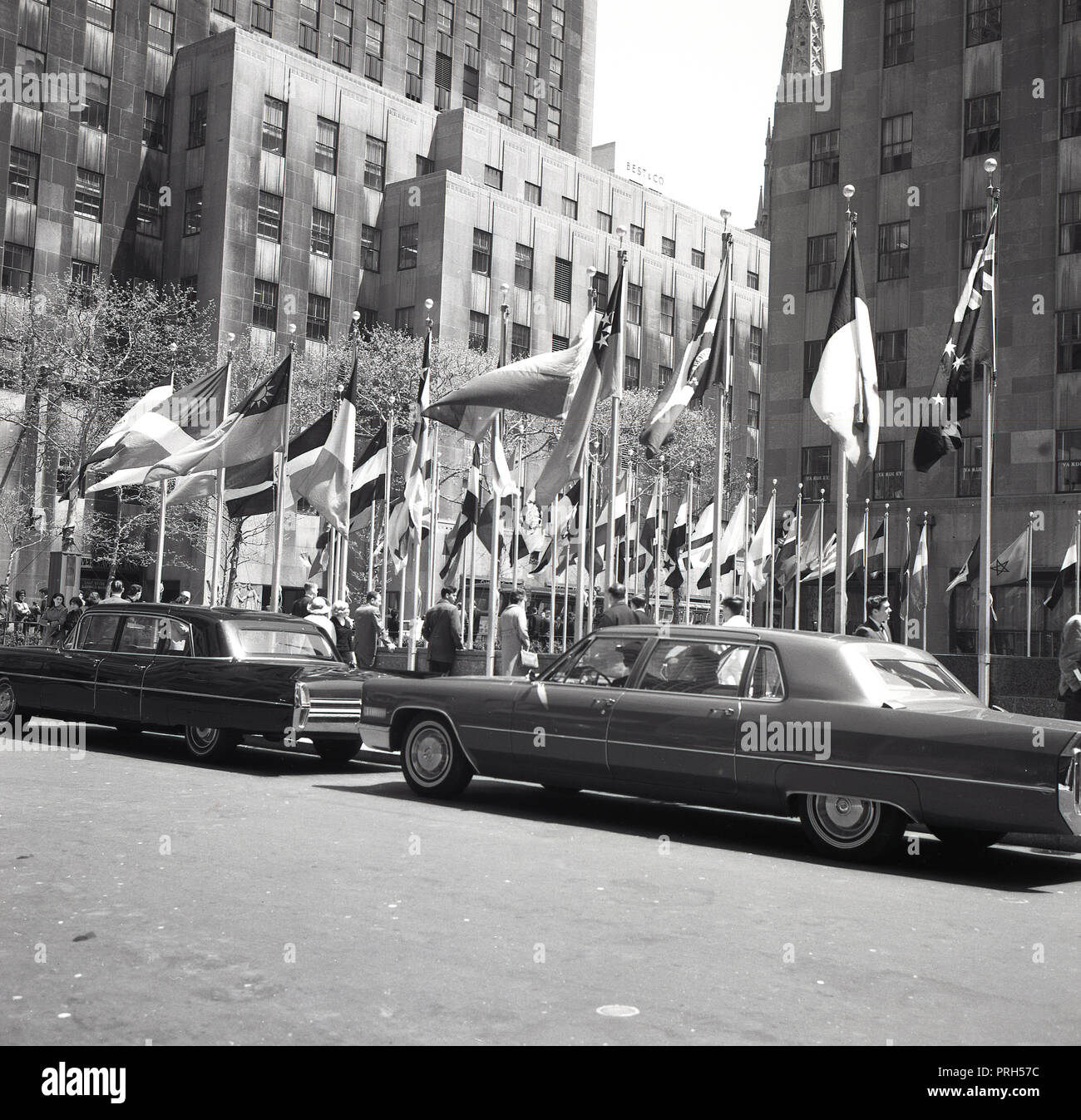 1950er Jahre, historische, luxuriöse Limousinen in der Straße vor dem Rockefeller Center, New York City, NY, USA geparkt. Stockfoto