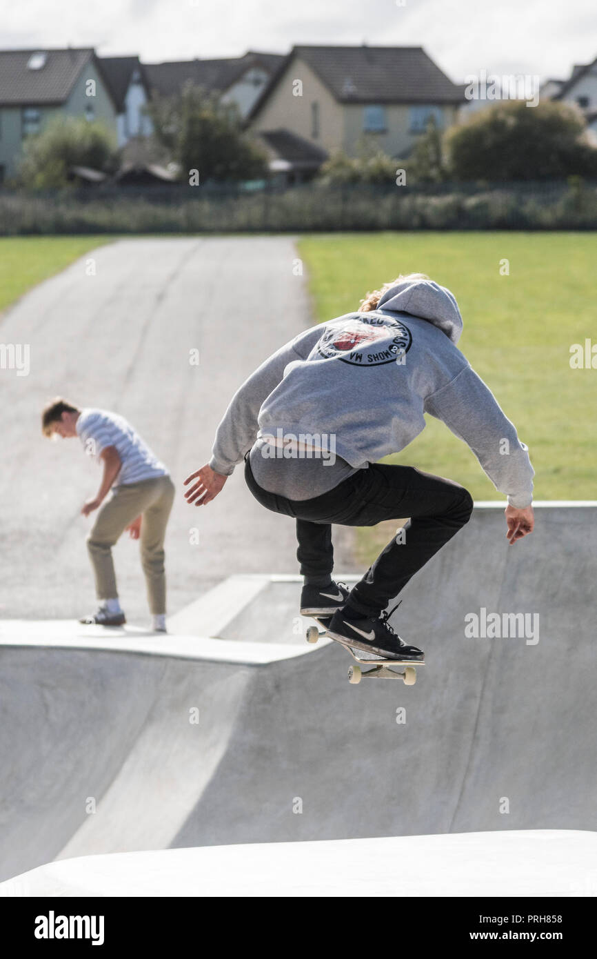 Ein Skateboarder Durchführen einer skateboarding Antenne Trick an konkreten Wellen in Newquay in Cornwall. Stockfoto