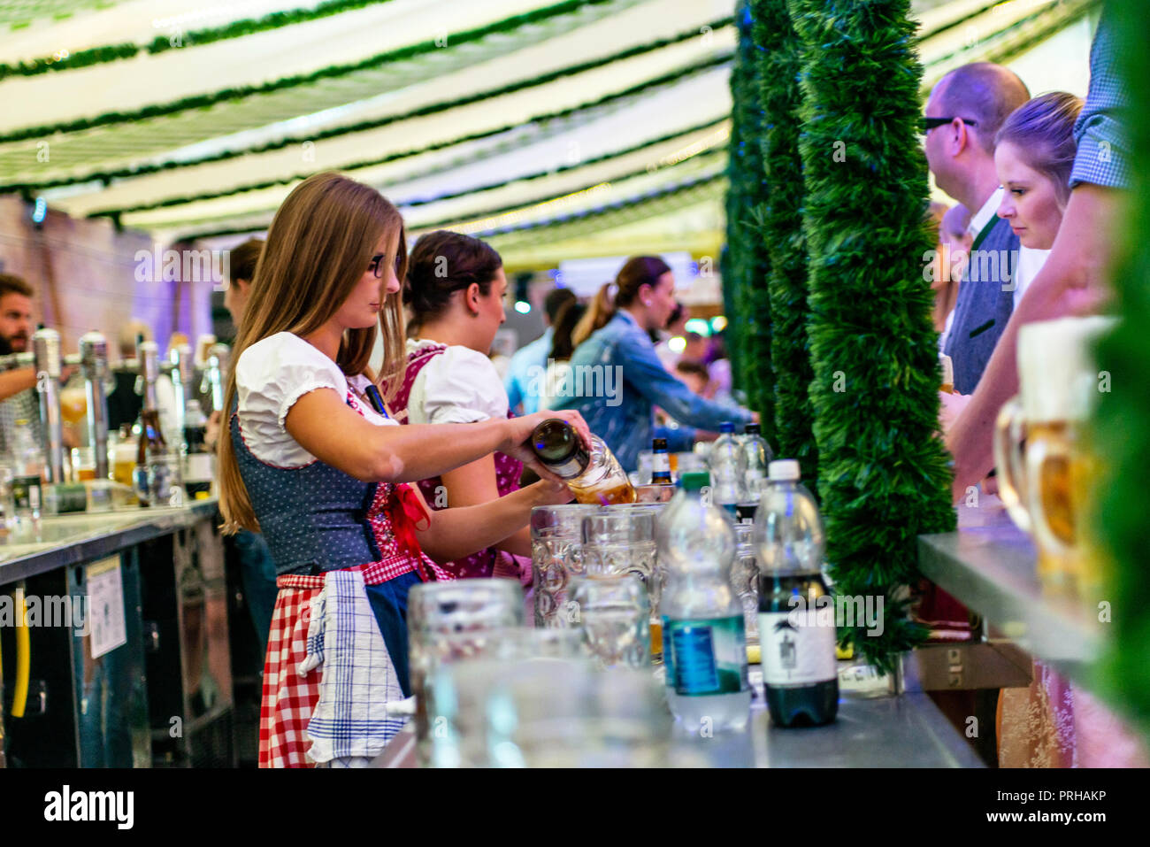 Koblenz Deutschland -26.09 .2018 schöne Mädchen im Dirndl holding Tassen füllten sie mit Bier Hintergrund Oktoberfest Brille. Stockfoto