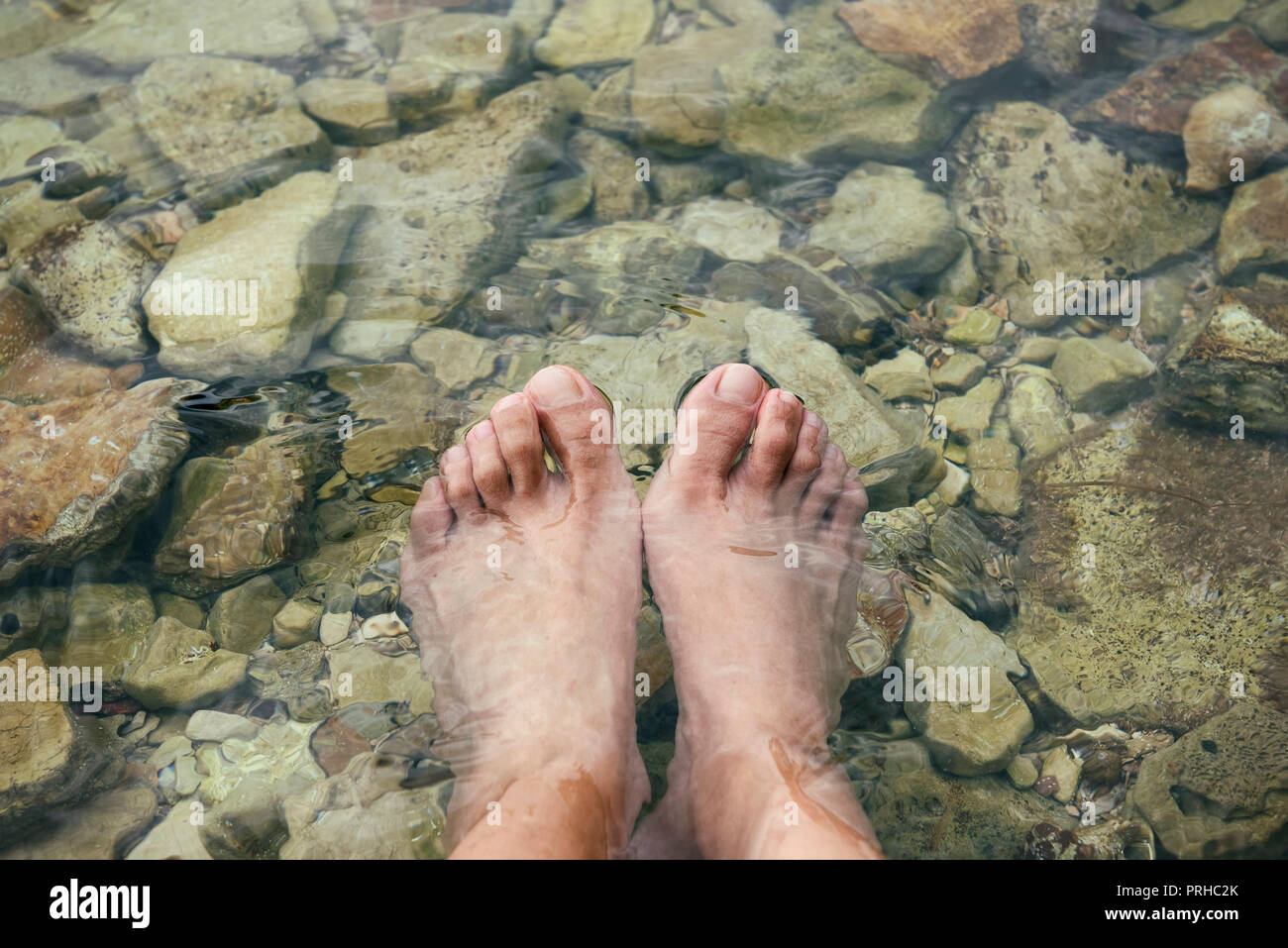 Weibliche Füße im Wasser (Strand) Stockfoto