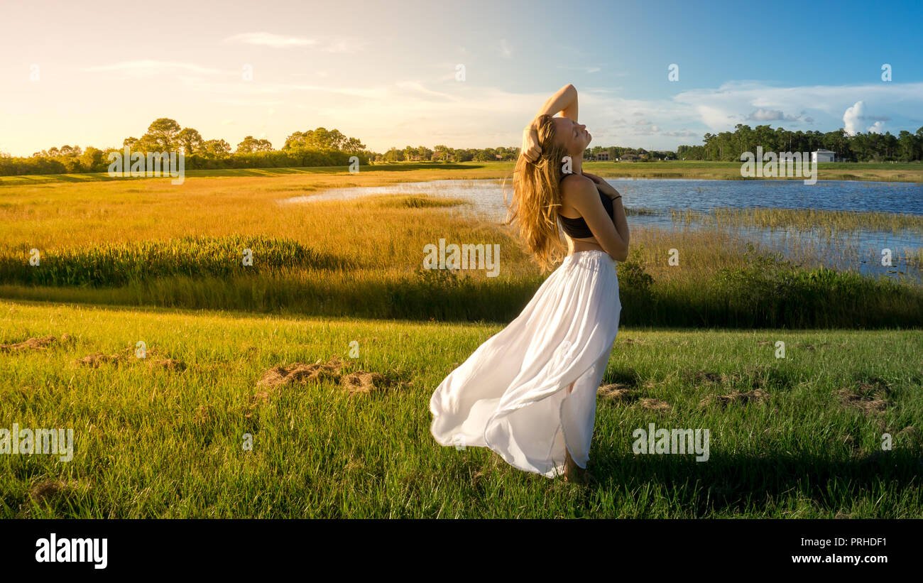 Junge Blonde Frau Im Querformat Mit Friedlichen Gesicht Bei Sonnenuntergang Rock Haar Vom Wind Ausgeblasen Gelb Weiches Licht Stockfotografie Alamy