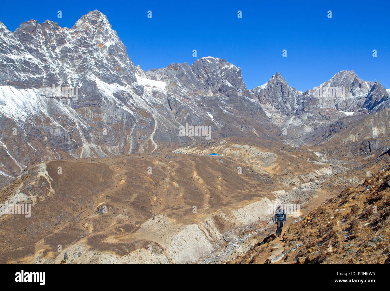 Trekker oberhalb des Dorfes Dzongla, auf der Abfahrt von Cho La in Richtung Everest Base Camp Stockfoto