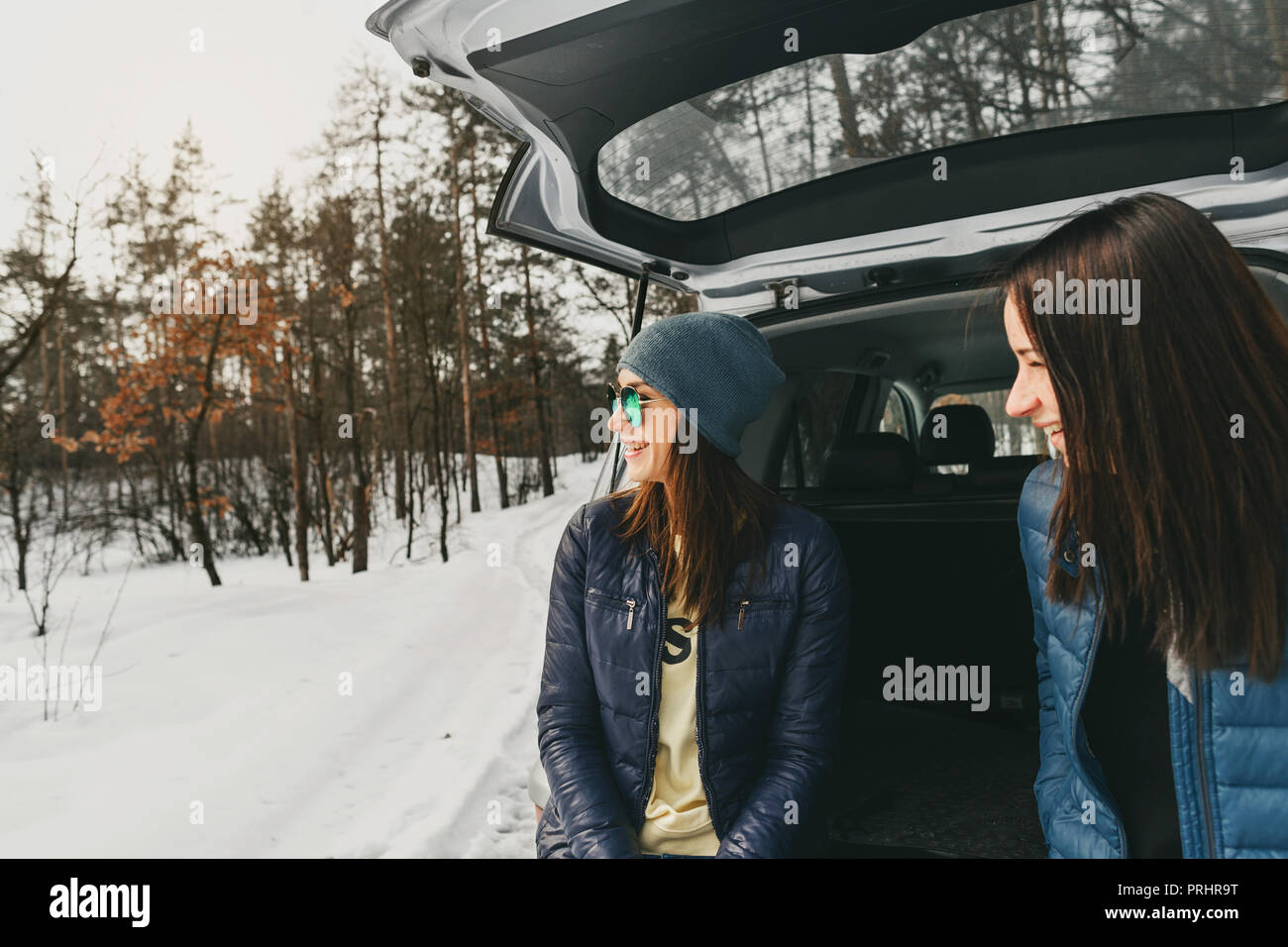 Freundinnen im Winter tragen auf verschneiten Tag im Winter Forest im Auto Stockfoto
