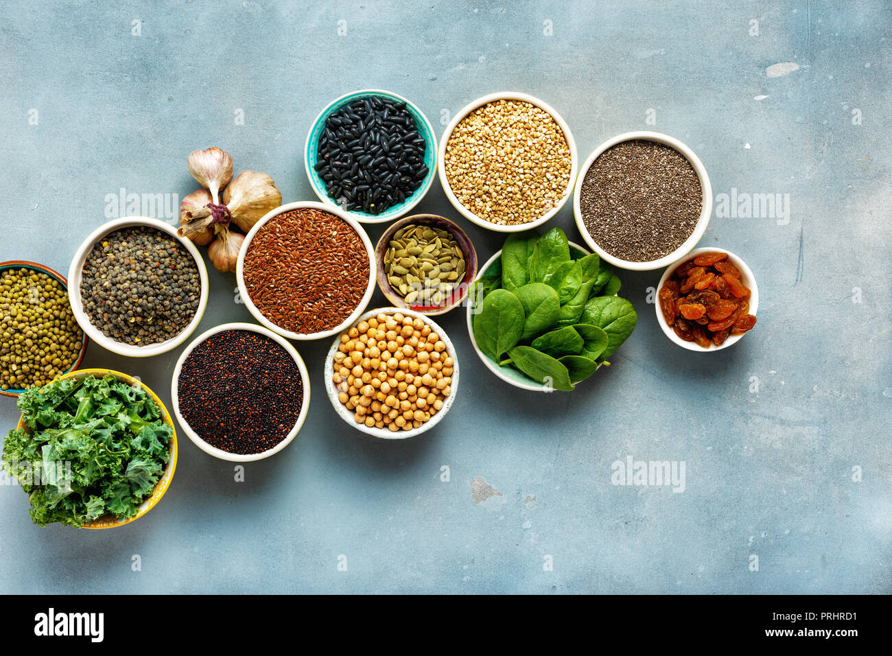 Super Essen oder vegetarisches Essen Konzept. Samen, Getreide, Bohnen, Gemüse, Kräuter für gesundes Kochen auf blauen Stein Hintergrund Draufsicht mit Kopie Raum Stockfoto