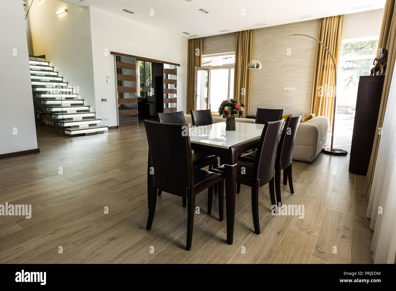 Innenansicht der modernen Esszimmer mit Tisch, Stühlen und Treppen Stockfoto