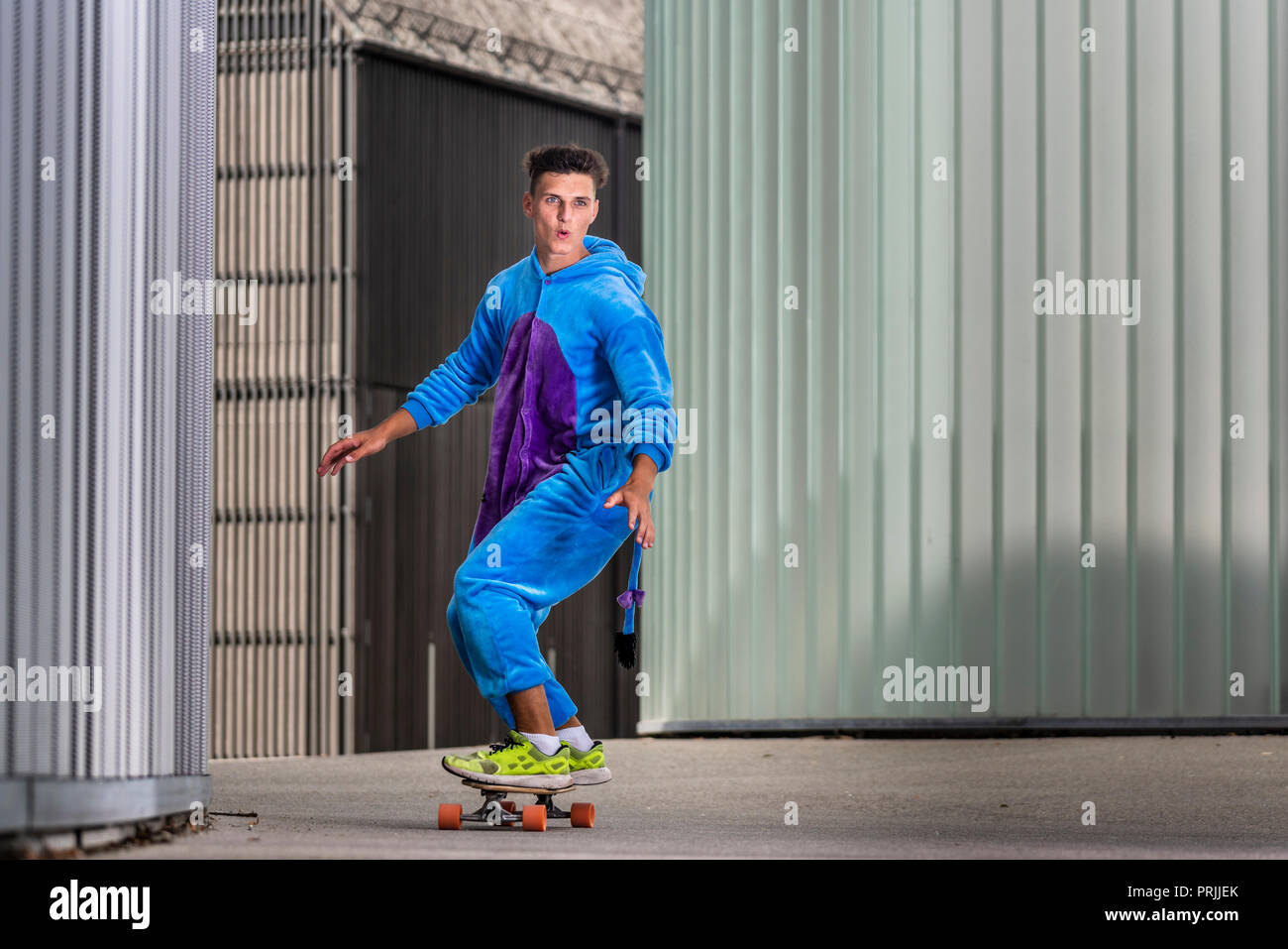 Teenager, 17 Jahre, Fahrten Longboard trägt ein einteiliges, Deutschland Stockfoto