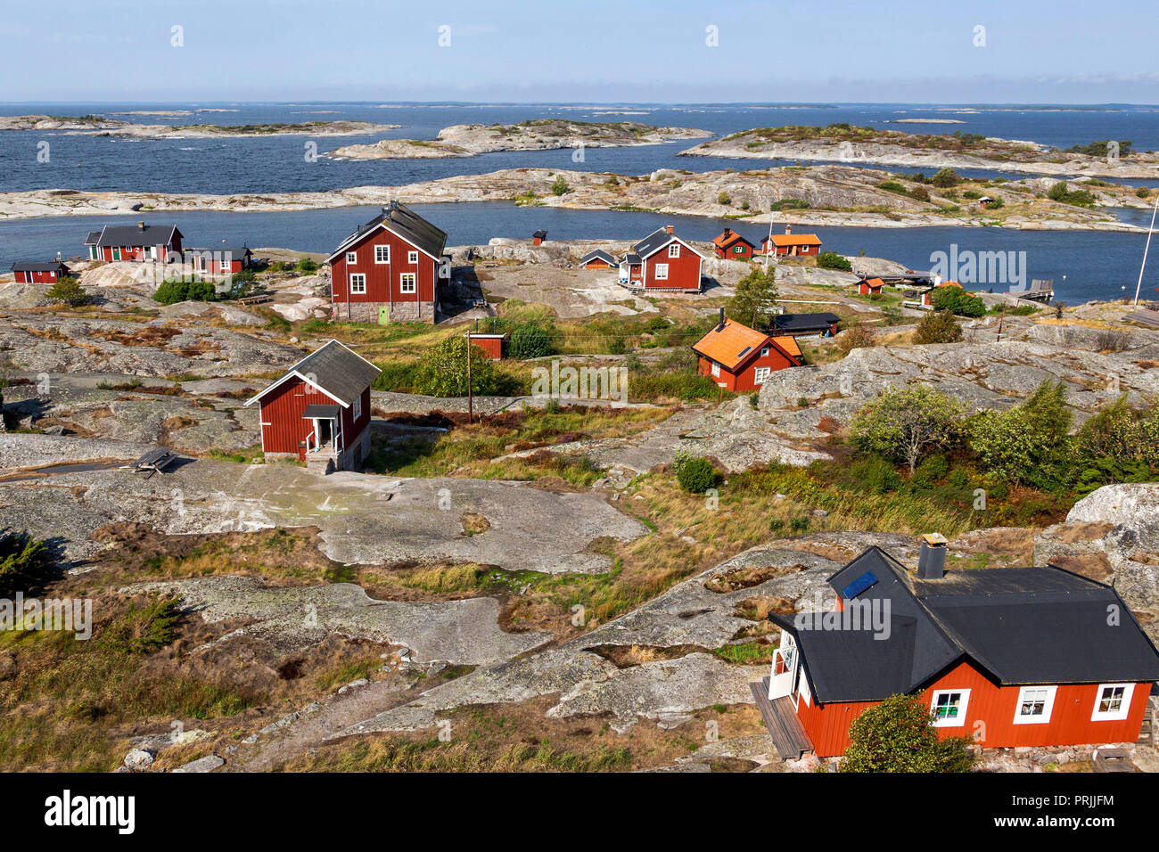 Rote Holzhäuser an der felsigen Küste, Stockholmer Schären, Huvudskär Archipel Insel, Schweden Stockfoto