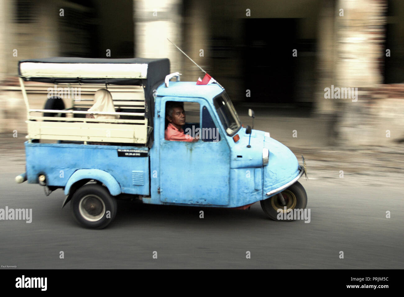 Bajaj Auto Rikscha transportiert Menschen entlang einer Stadtstraße in Padang, Indonesien Stockfoto