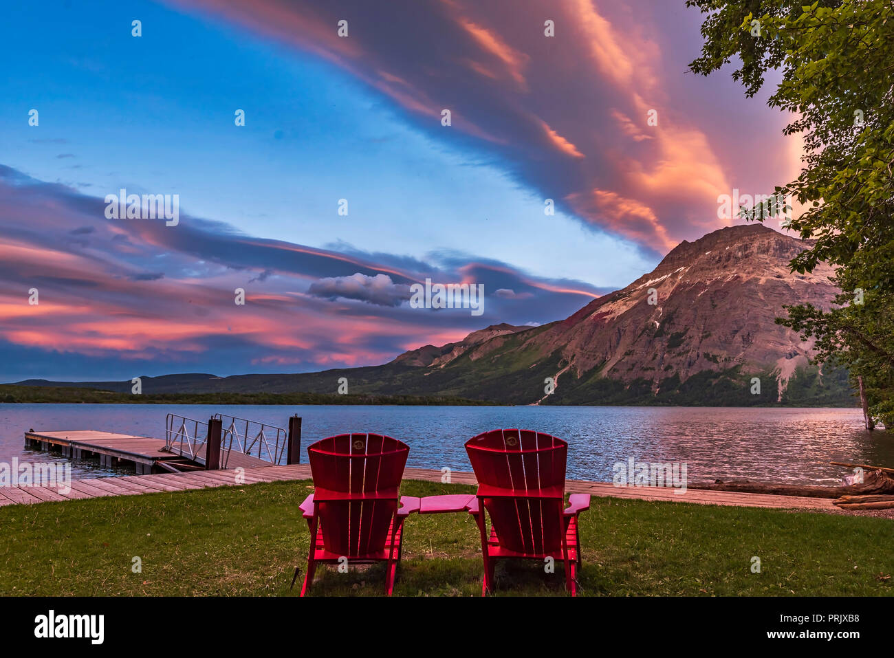 Die legendären roten Stühlen der Parks Kanada im Licht der untergehenden Sonne in der Mitte des Waterton Lake in Waterton Lakes National Park, am 17. Juni 2017. Vimy Peak ist bei r Stockfoto