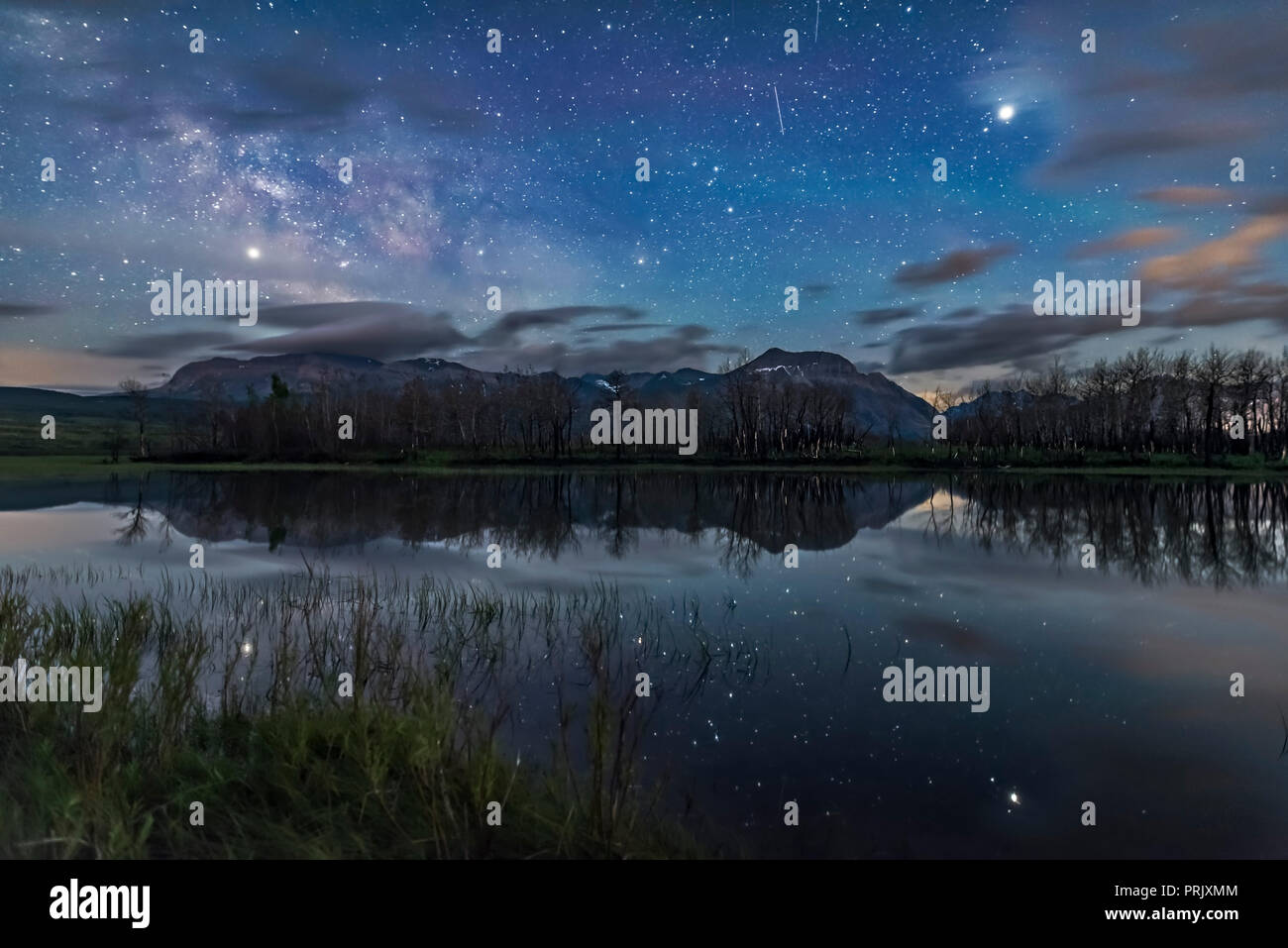 Jupiter (rechts) und Saturn (links) Hell am Himmel scheint und spiegelt sich in den stillen Wassern des Maskinonge See in Waterton Lakes National Pa Stockfoto