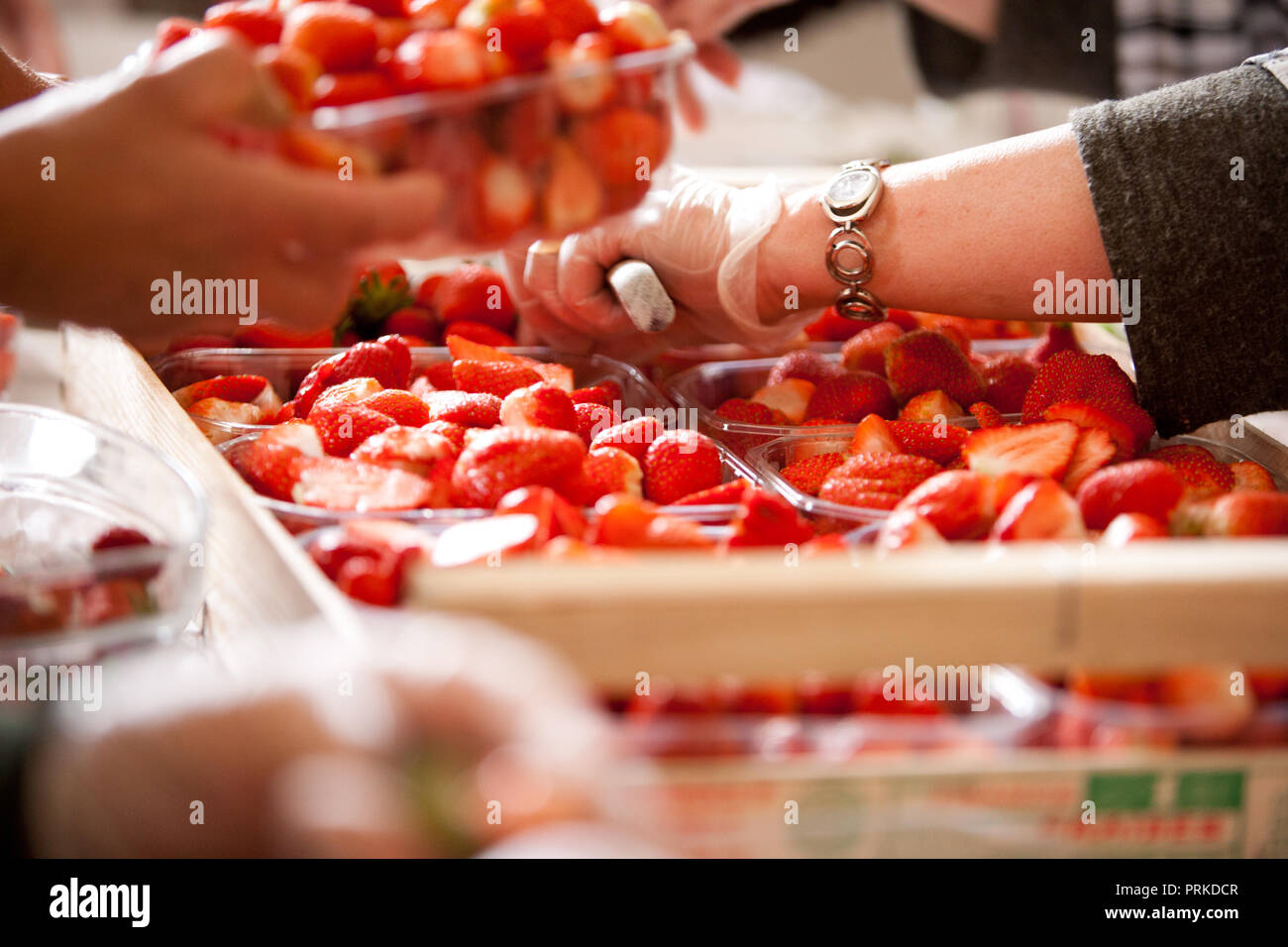 Professionelle Frauen Vorbereitung eine große Erdbeerkuchen Stockfoto