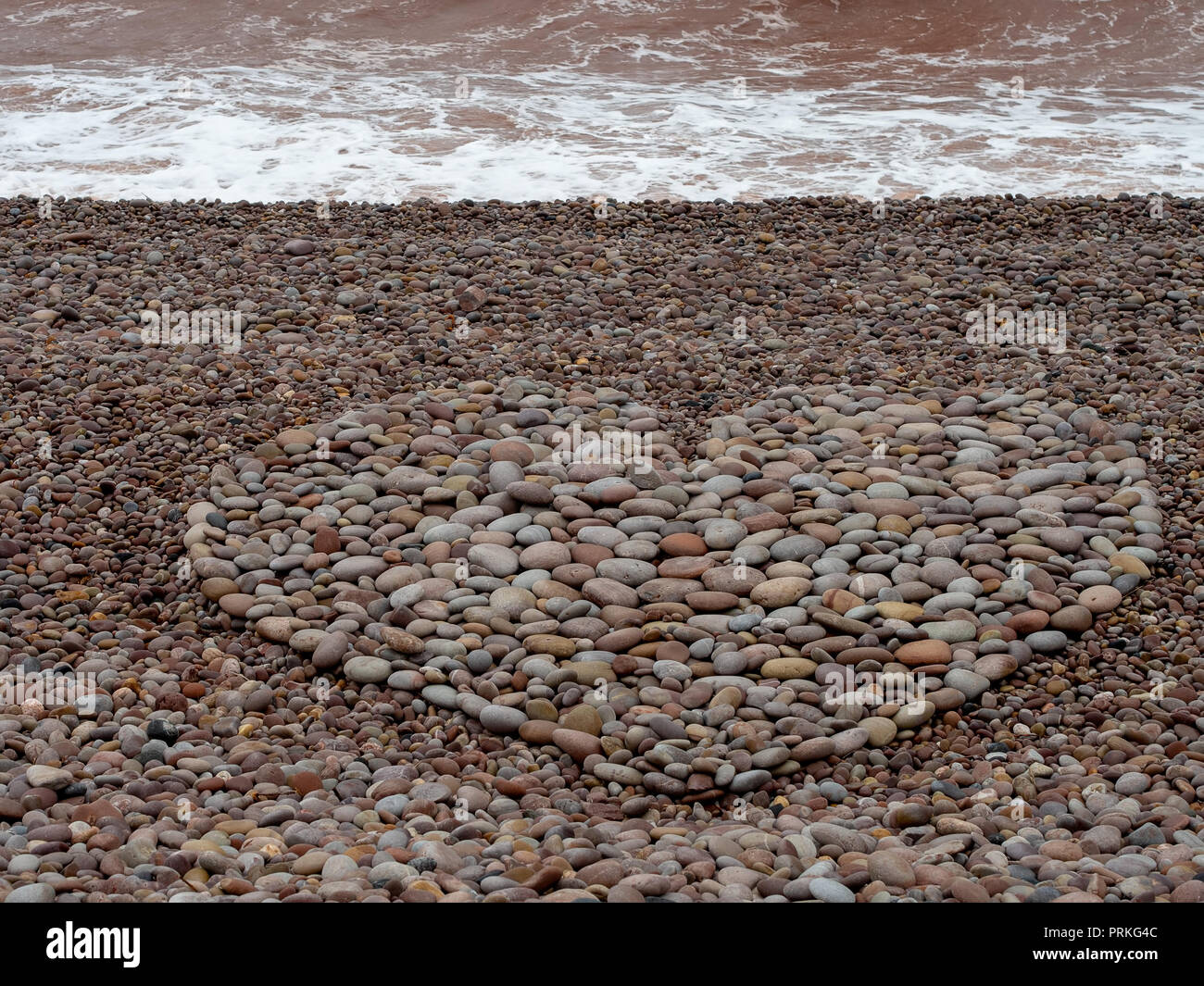 Große Liebe Herz Form mit Kieselsteinen am Strand gemacht. Stockfoto