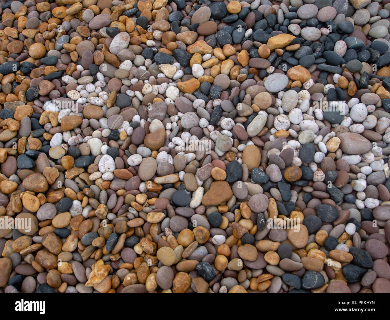 Meer Kieselsteine am Strand, verschiedenen Farben und Arten von Stein. Bunte Steine - Schwarz, Weiß, Gelb. Stockfoto