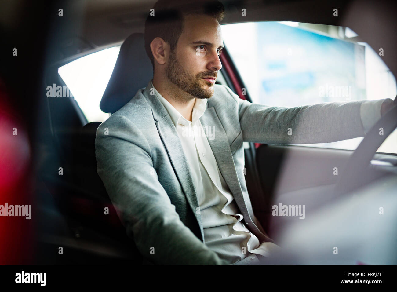 Ein Geschäftsmann, der ein Auto fährt, schaltet die Musik im Auto-Player  ein, ein Mann vor einer Reise in einem Geschäftsanzug Stockfotografie -  Alamy