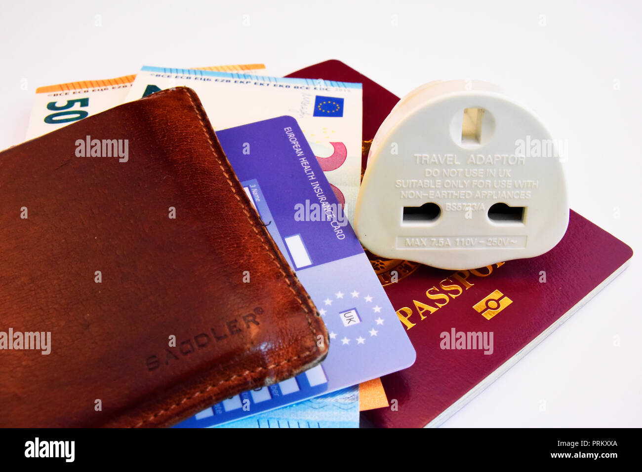 Europäische Union Vereinigtes Königreich von Großbritannien und Nordirland biometrischen Pass mit Euro Geldscheine, EHIC Karte und Travel Adapter Stecker Stockfoto