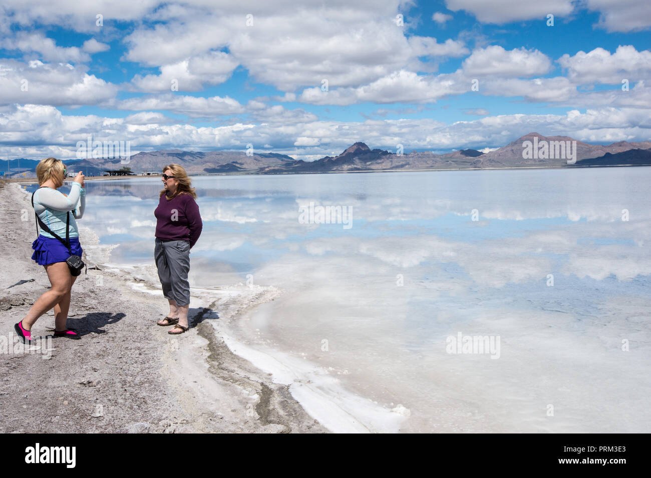 Die Tochter nimmt Fotos ihrer Mutter an der Bonneville Salt Flats in Utah Stockfoto