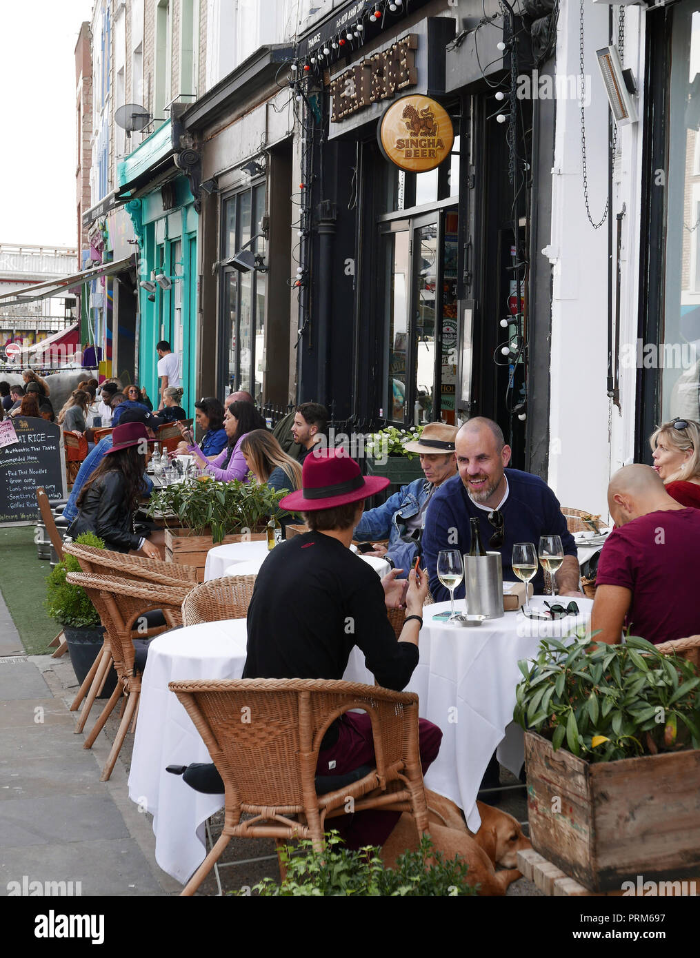 Die Menschen essen im Roadside Cafés in der Portobello Road in London W11 Stockfoto