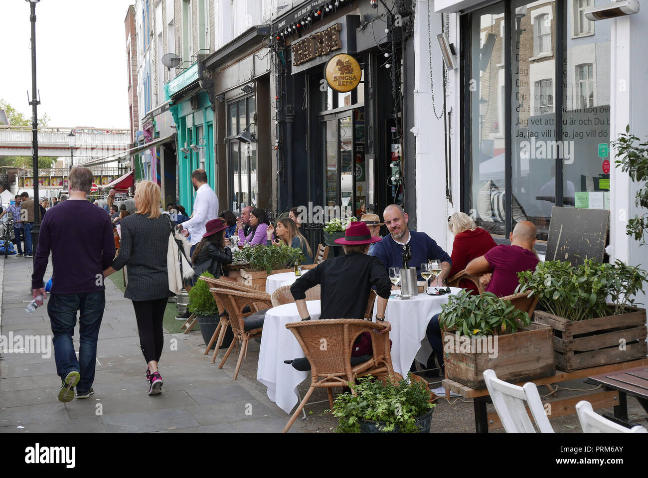 Die Menschen essen im Roadside Cafés in der Portobello Road in London W11 Stockfoto