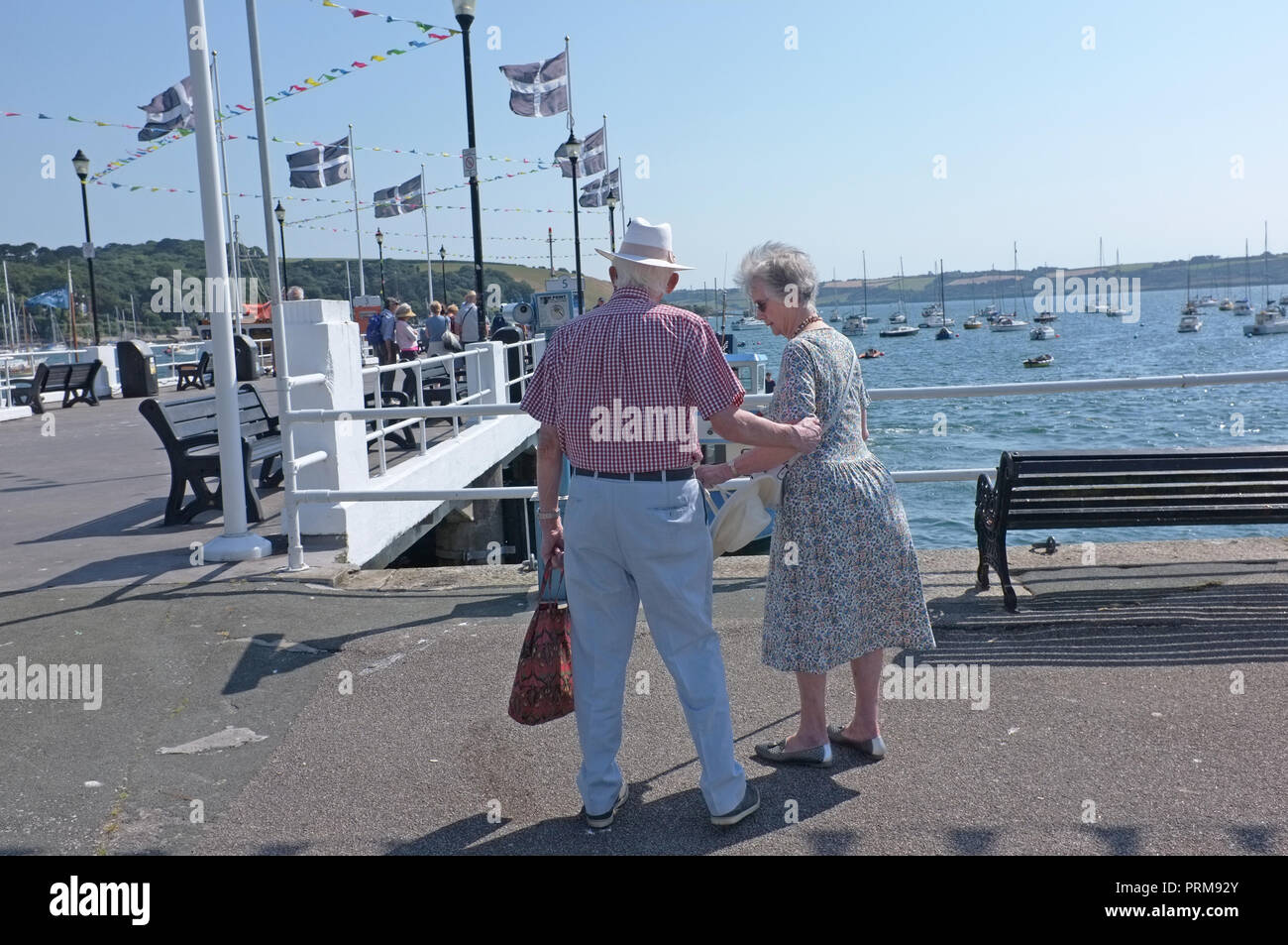 Ein altes Rentnerehepaar, Hände auf einem Pier in Cornwall. Stockfoto