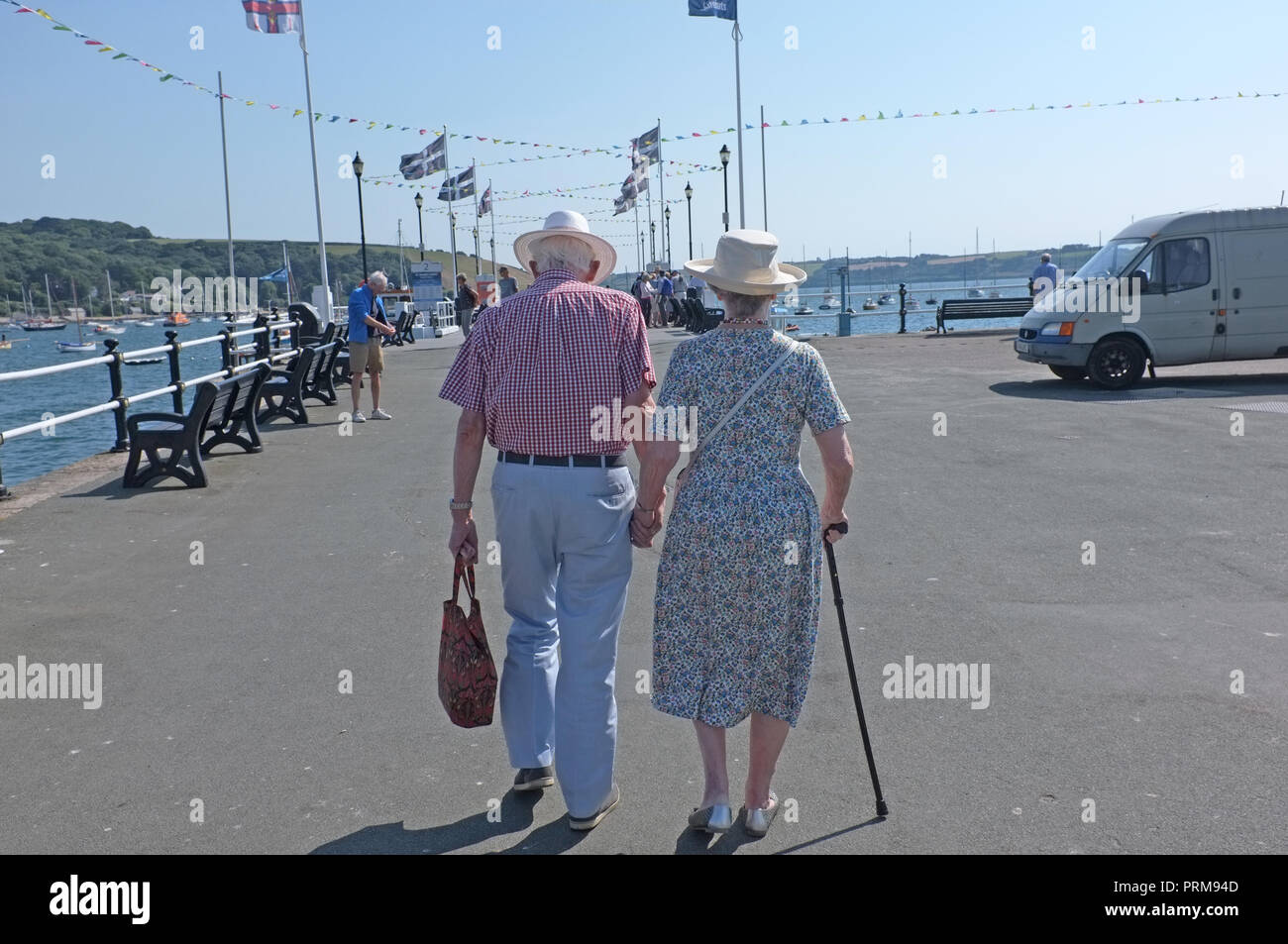 Ein altes Rentnerehepaar, Hände auf einem Pier in Cornwall. Stockfoto