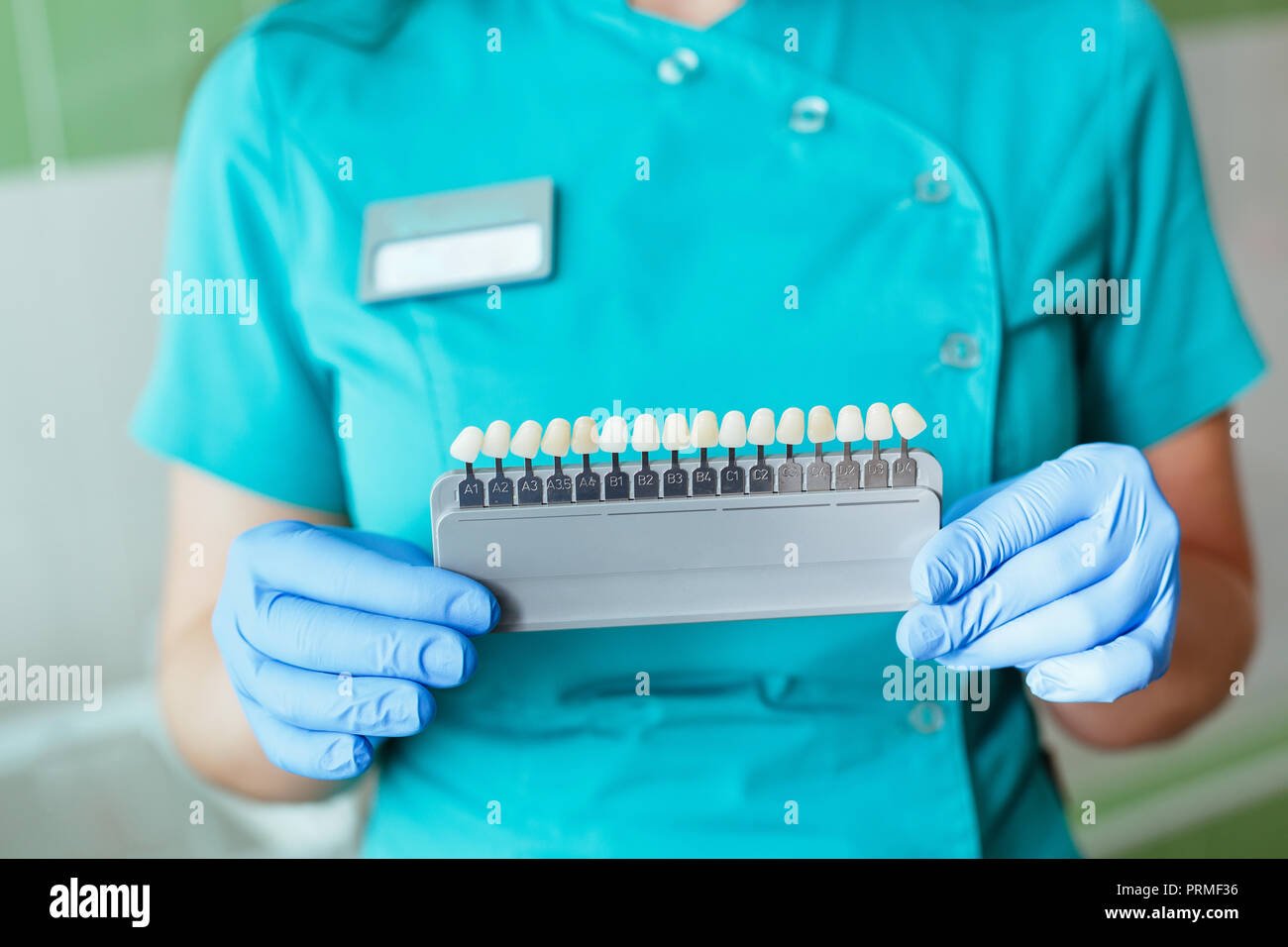 Zahnarzt in Händen halten, die mit den Schattierungen oder Farbe der Implantate oder der Prozess der Zähne, die. Stockfoto