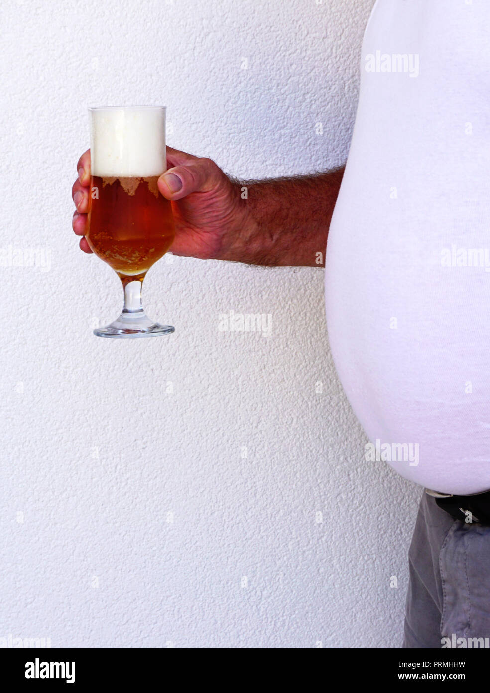 Großes Bier Bauch Mann hält ein Glas voll Bier, Blasen und Bier Schaum auf weißem Hintergrund Stockfoto