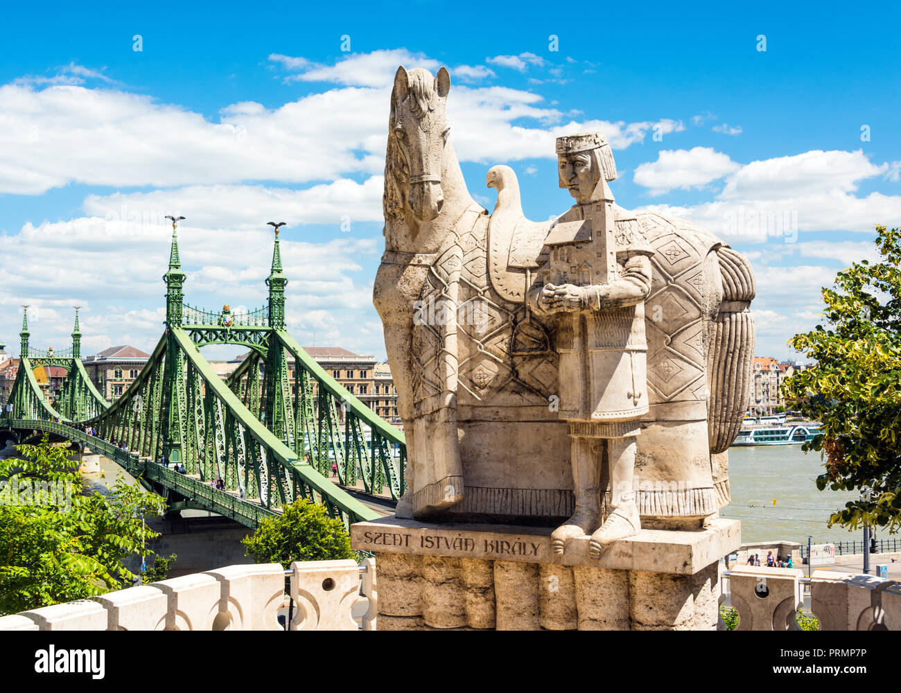 Ein Stein Statur von König Stephen, der Heiligen und der erste König von Ungarn, mit Liberty Bridge im Hintergrund, Budapest, Ungarn Stockfoto