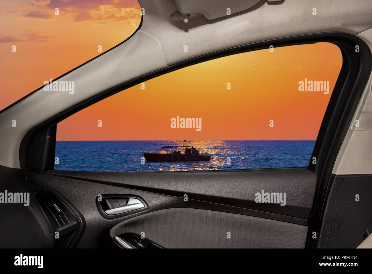 Blick aus dem Seitenfenster des Autos auf der wunderschönen Meereslandschaft mit Boot Stockfoto