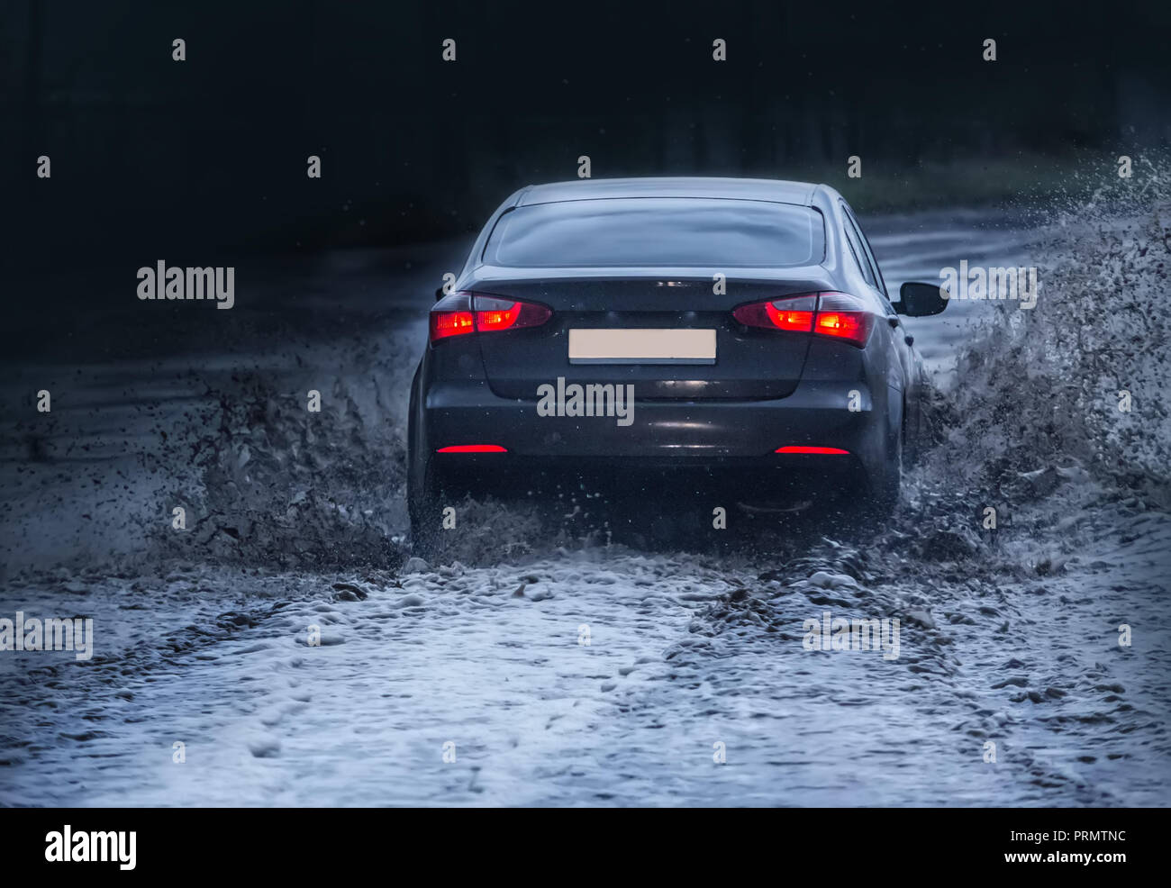 Auto bewegt sich auf einer nassen Straße im regen Stockfoto