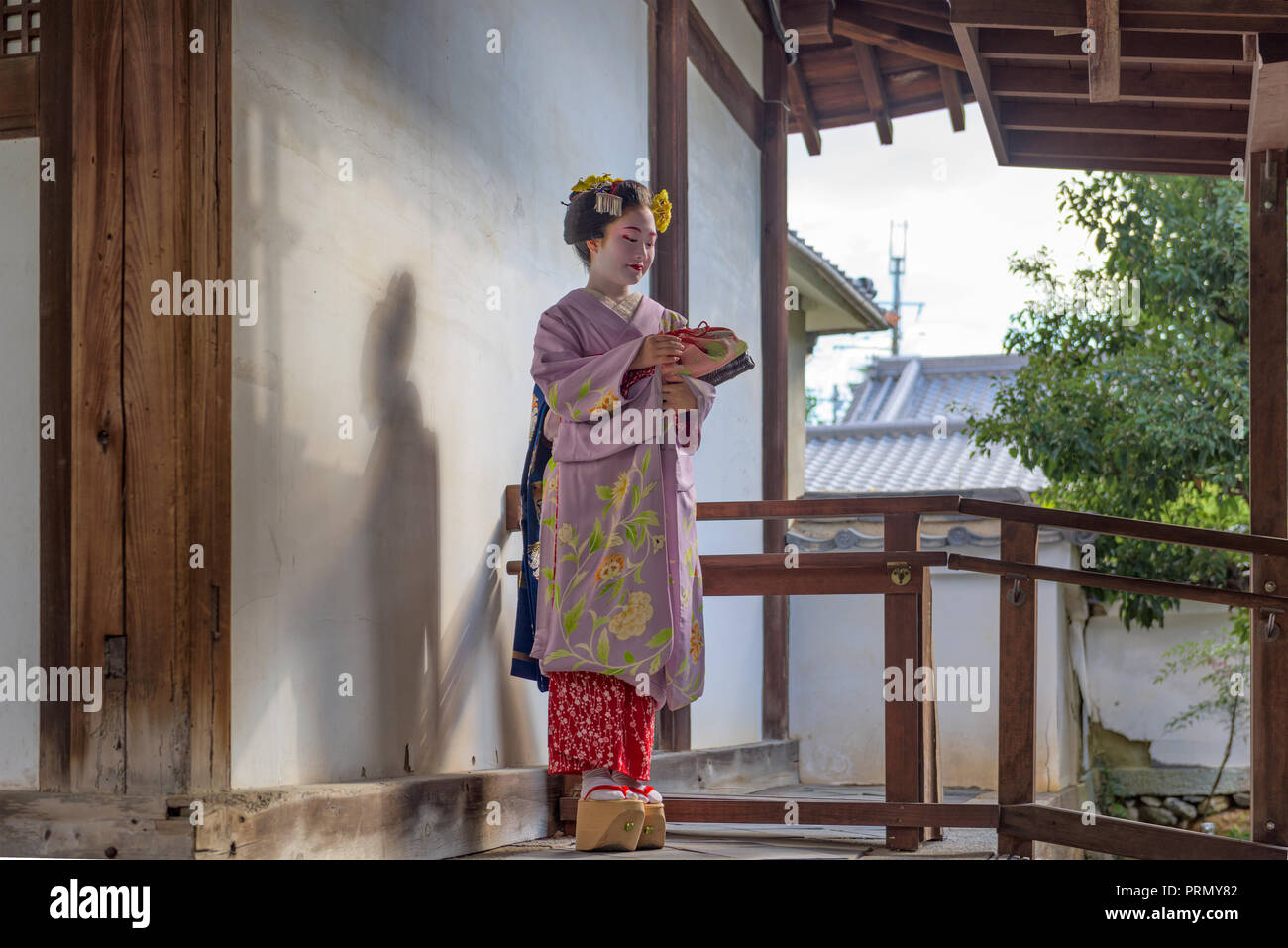 KYOTO, Japan - 28. NOVEMBER 2015: eine Frau in der traditionellen Maiko Kleid auf einem Tempel Tür. Stockfoto