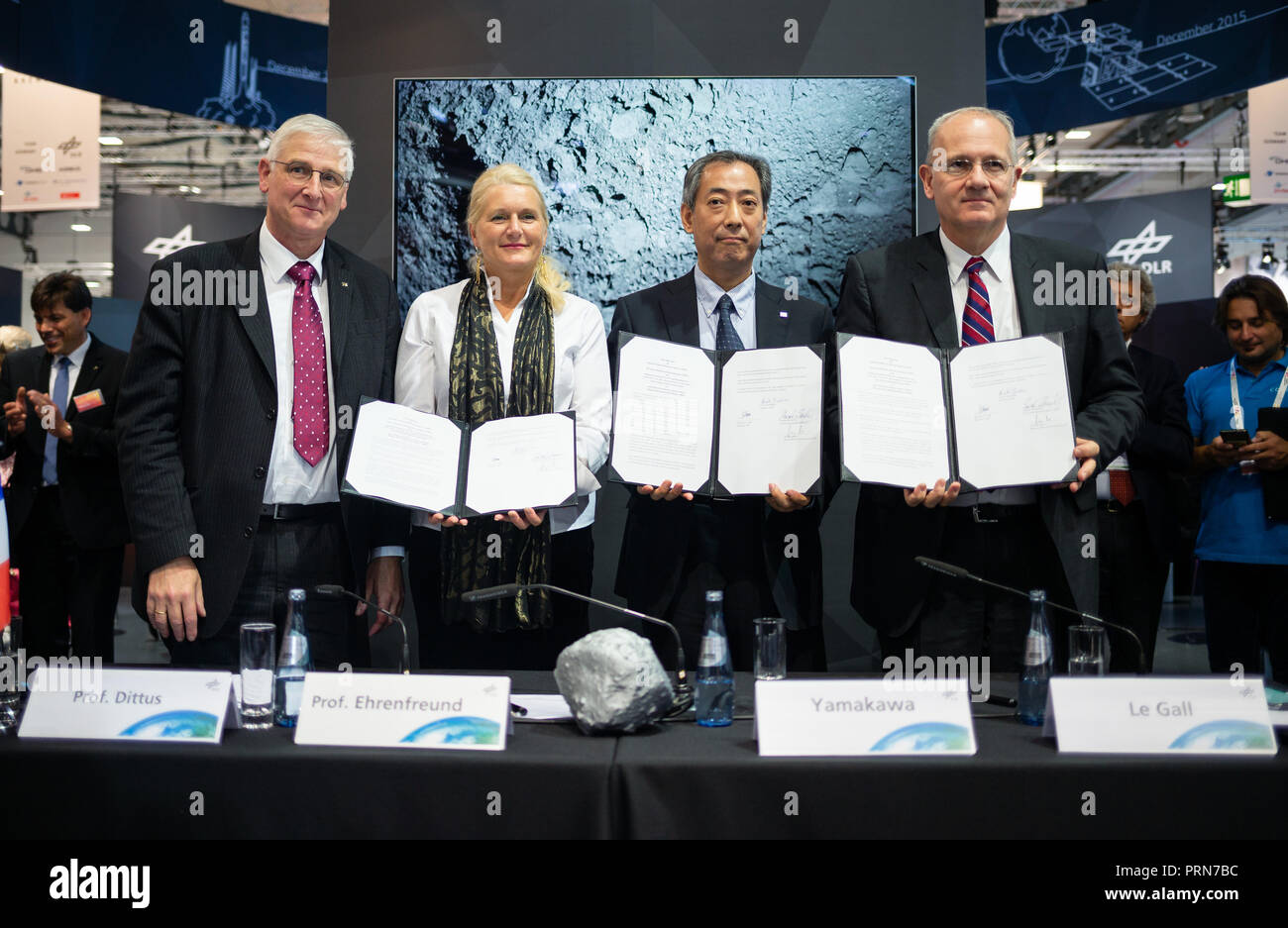 03 Oktober 2018, Bremen: Hansjörg Dittus (L-R), Vorstandsmitglied des Deutschen Zentrums für Luft- und Raumfahrt (DLR), Pascale Ehrenfreund, Sie vom Deutschen Zentrum für Luft- und Raumfahrt (DLR), Hiroshi Yamakawa, Präsident von Japan Aerospace Exploration Agency (JAXA) und Jean-Yves Le Gall, Präsident der Internationalen Astonautical Federation (IAF) sind beim 69. International Astronautical Congress IAC bei der Pressekonferenz zur Landung des Landers "ASCOT" mit dem Asteroiden Ryugu und halten den unterschriebenen Vertrag in dreifacher Ausführung zu Marsmond eXploration (MM Stockfoto