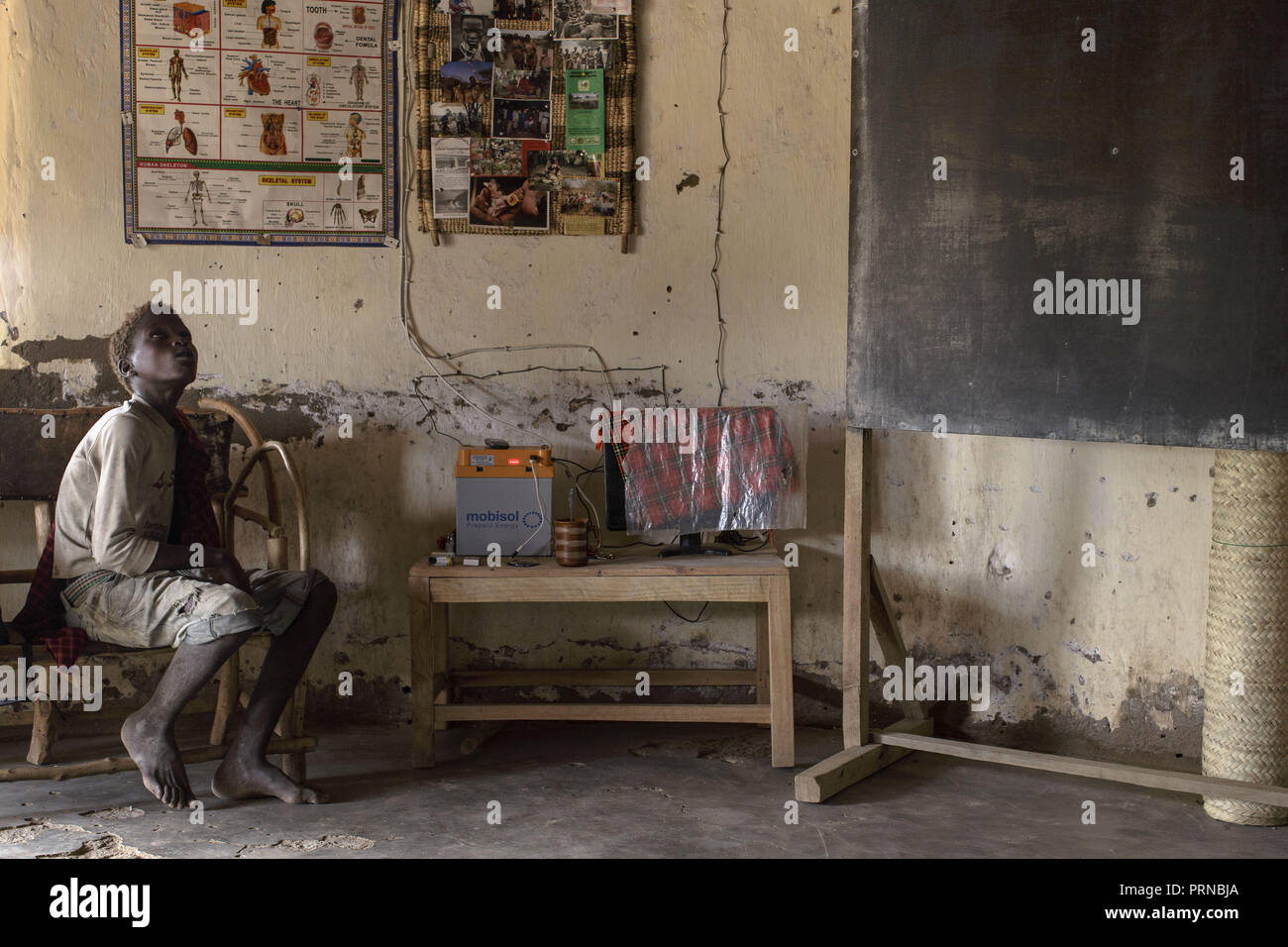 Mai 3, 2017 - Lake Eyasi, Ngorongoro, Tansania - Osama, 14, tritt in einer Schule zum ersten Mal in seinem Leben. Er schaut auf die Umgebung und die Elemente, die an den Wänden erstaunt. Der hadza Eine der letzten verbleibenden Gesellschaften, die in der Welt bleiben, dass rein vom Jagen und Sammeln überleben. Sehr wenig wurde in der Art und Weise, wie der Hadza ihr Leben verändert. Aber es wurde immer schwieriger für sie zu verfolgen die Hadza Lebensart geworden. Entweder die Hadza wird einen Weg finden, ihr Land zu sichern - Rechte den Zugang zu sauberem Wasser quellen und wilden Tieren, oder der Hadza zu haben Stockfoto