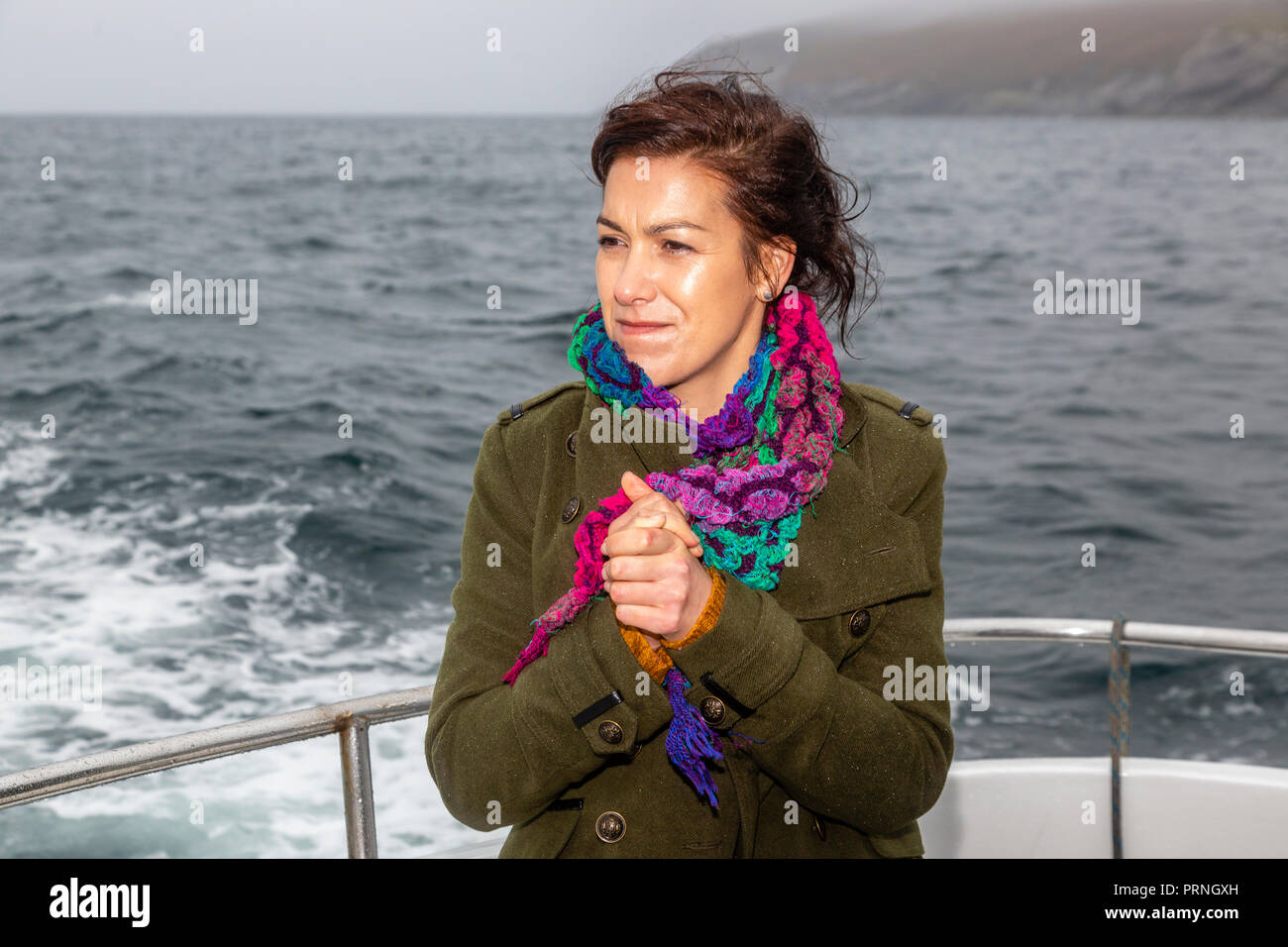 Junge Frau Gefühl der kalten Wetters auf Bootsfahrt von Portmagee County Kerry, Irland Stockfoto