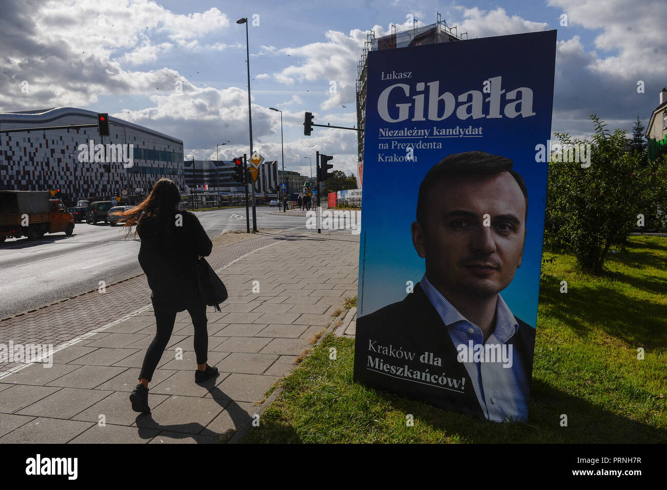 Eine Frau geht durch ein Plakat mit einem Kandidaten für die Bürgermeister von Krakau. Am 21. Oktober 2018 polnische Bürger wird für Tausende von Ratsmitgliedern und Bürgermeistern in regionalen, Grafschaft und Pfarrei Wahlen stimmen. Stockfoto