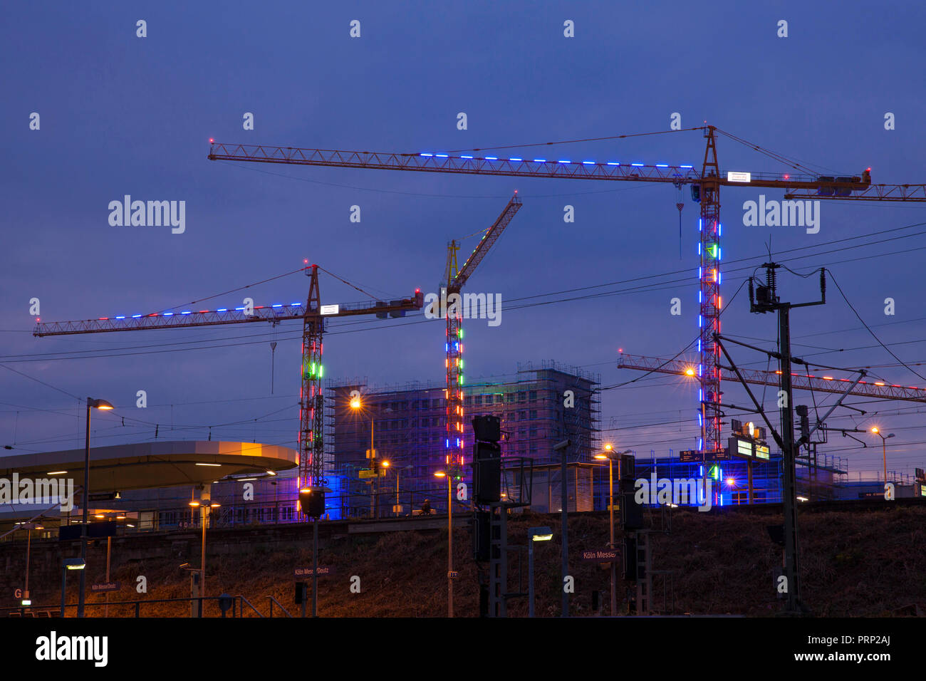 Beleuchtete Kräne auf der Baustelle für das Bauvorhaben MesseCity Koeln in der Nähe der Messegelände im Stadtteil Deutz, vor Stockfoto