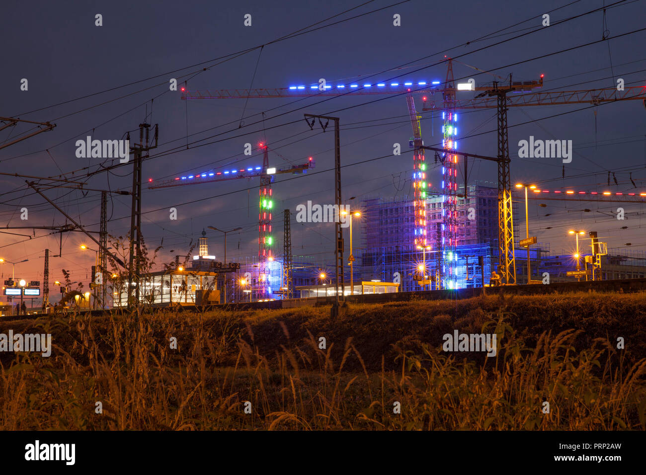 Beleuchtete Kräne auf der Baustelle für das Bauvorhaben MesseCity Koeln in der Nähe der Messegelände im Stadtteil Deutz, vor Stockfoto