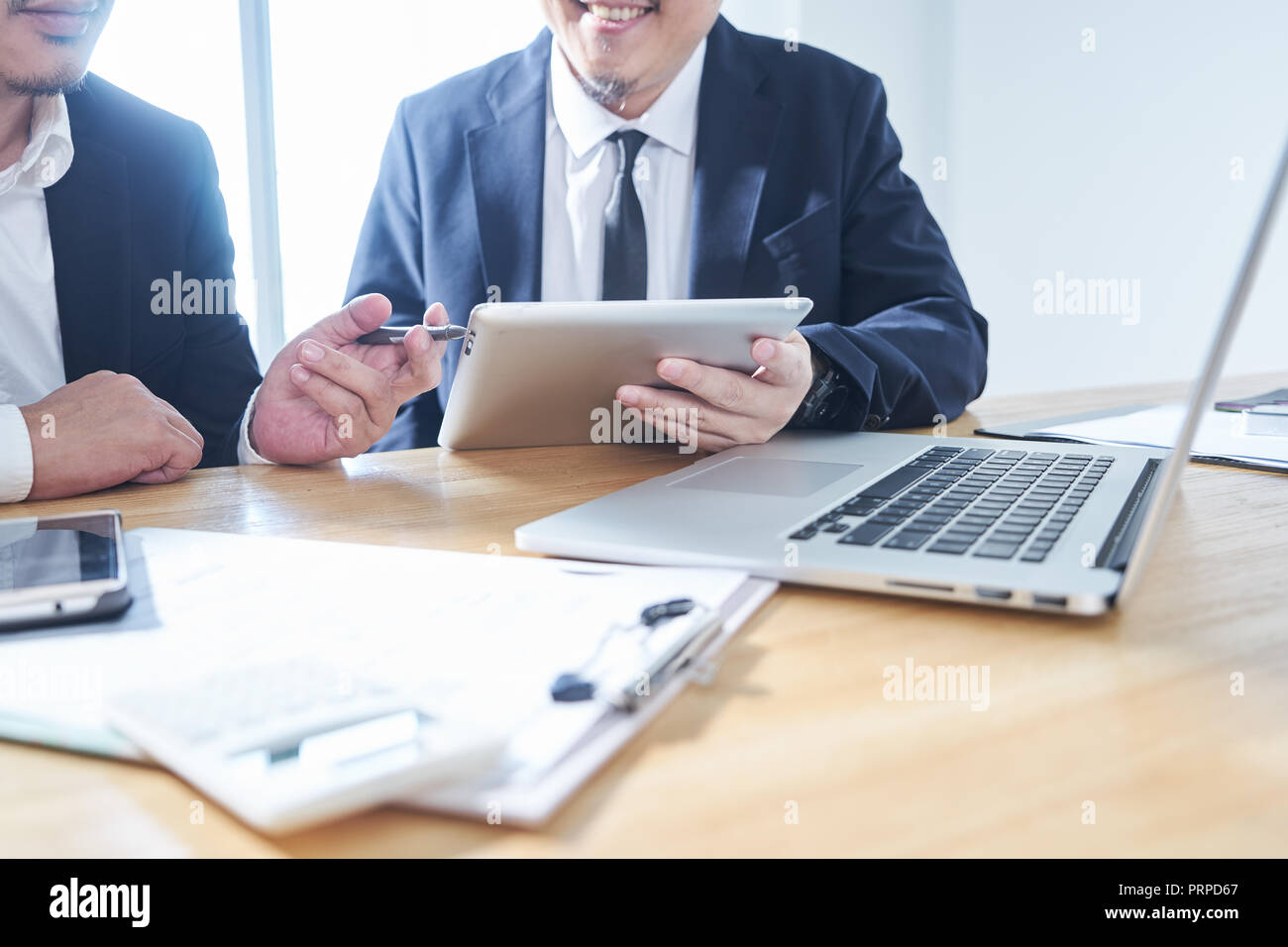 Zwei Geschäftsleute nutzen elektronische Produkte in der Diskussion über Business Plan Stockfoto
