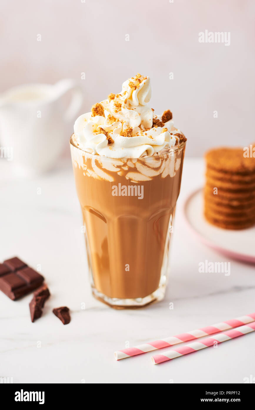 Schokolade Eis Kaffee mit Sahne und Cookies in ein hohes Glas mit rosa Strohhalme auf weißem Marmortisch über rose Hintergrund. Hochauflösendes Bild Stockfoto