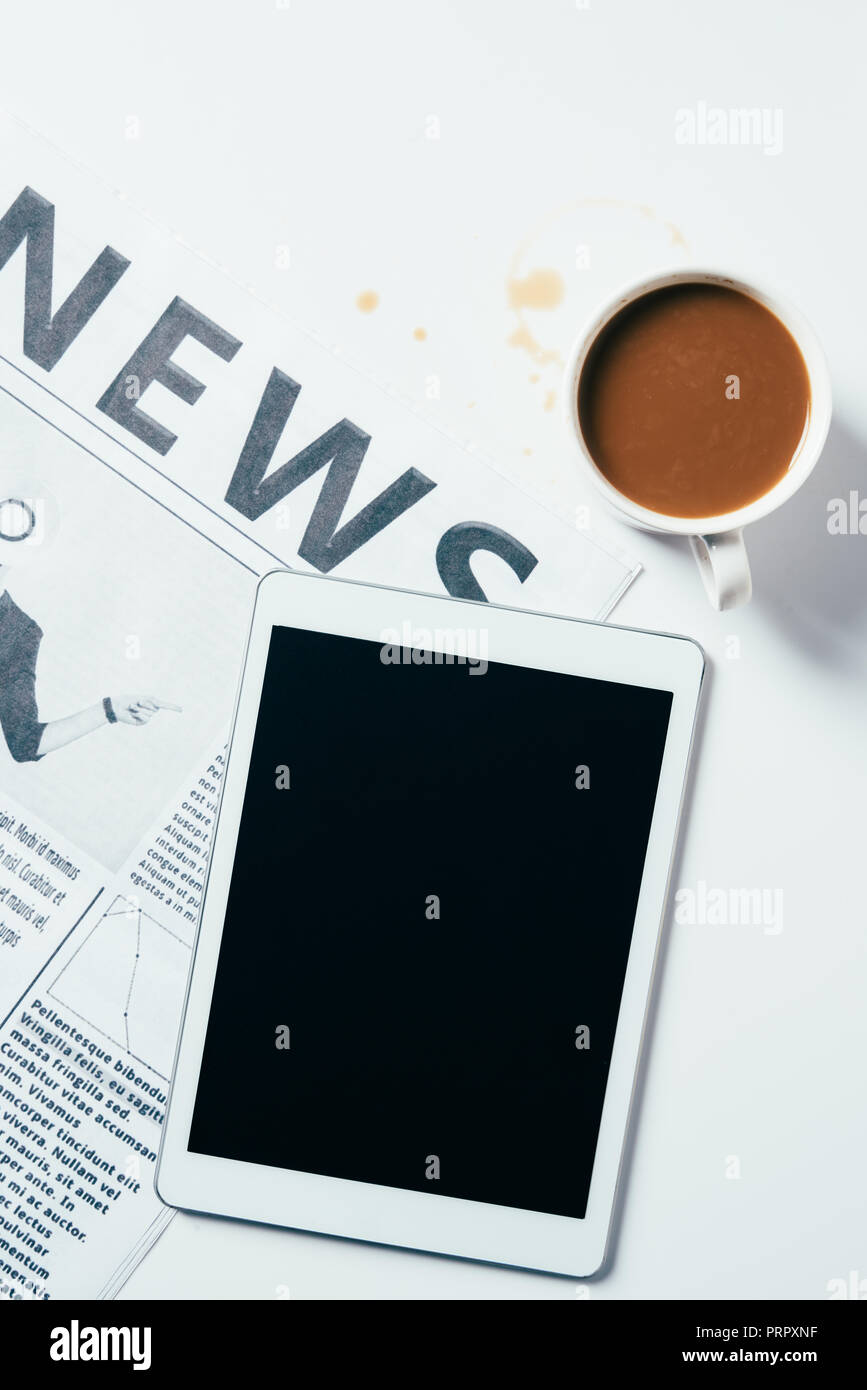 Blick von oben auf die Tablette mit der Tasse Kaffee und Zeitung auf weiße Oberfläche Stockfoto