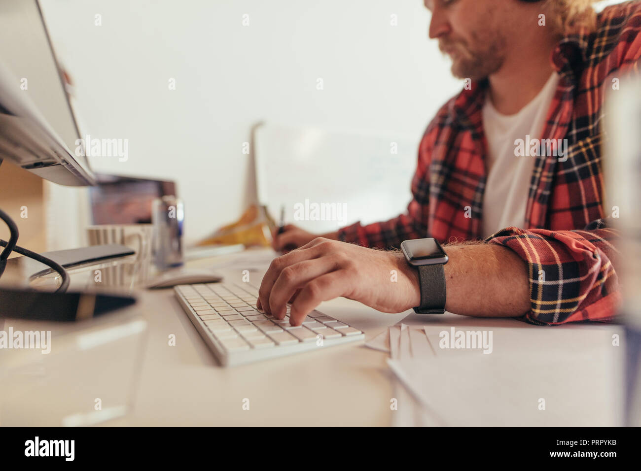 Die Hände des Menschen die Eingabe über Tastatur und Notizen im Büro. Programmierer am Schreibtisch arbeiten. Stockfoto