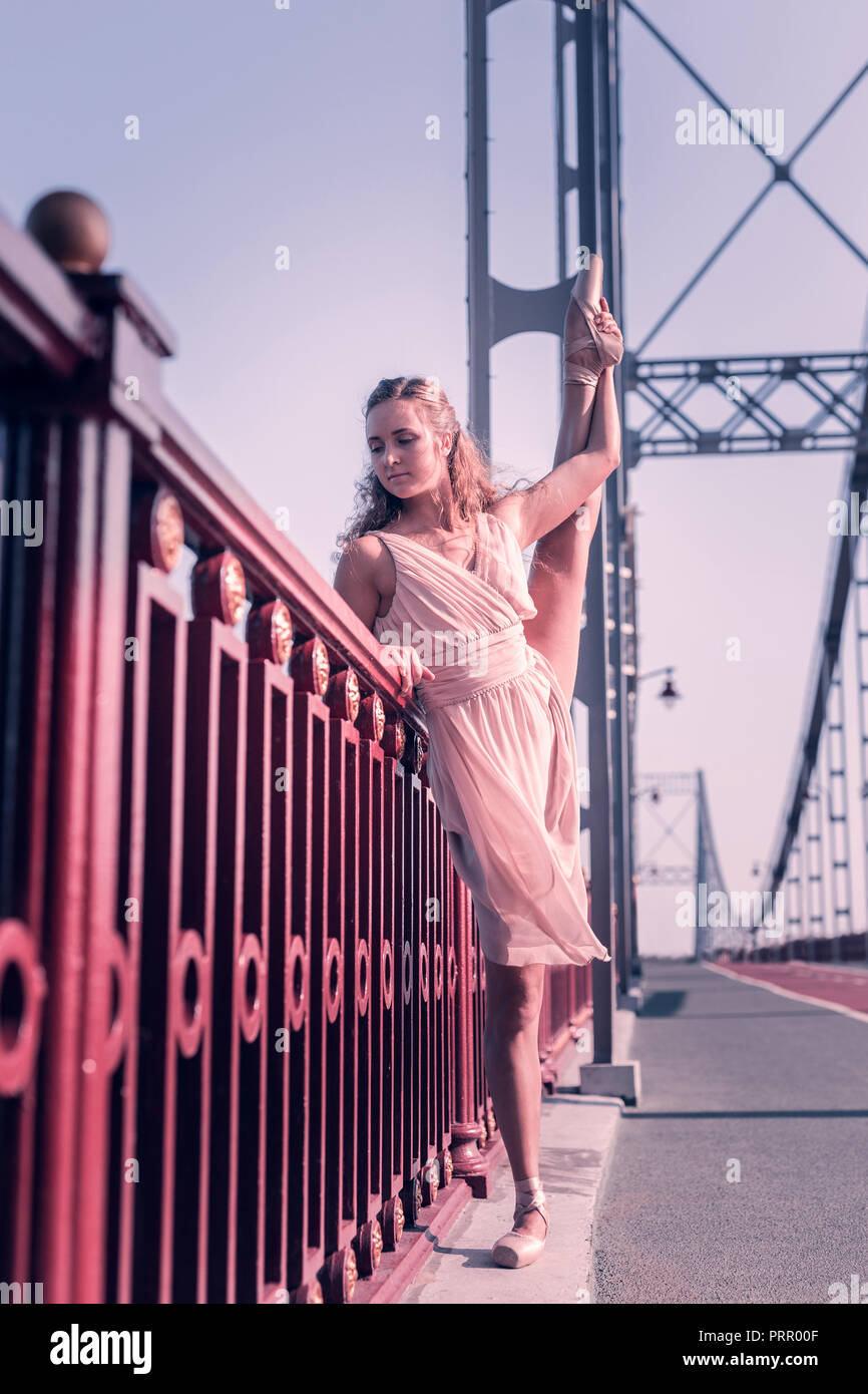 Angenehme schöne Ballerina stehend in der Nähe der Brüstung Stockfoto