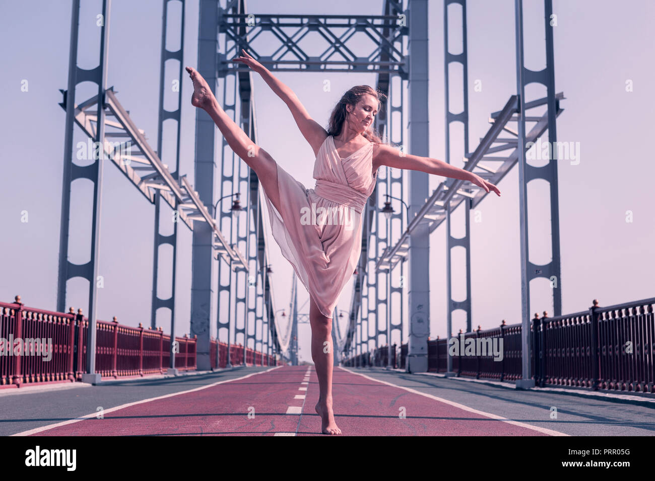 Attraktive angenehme Frau, die barfuß auf der Brücke Stockfoto