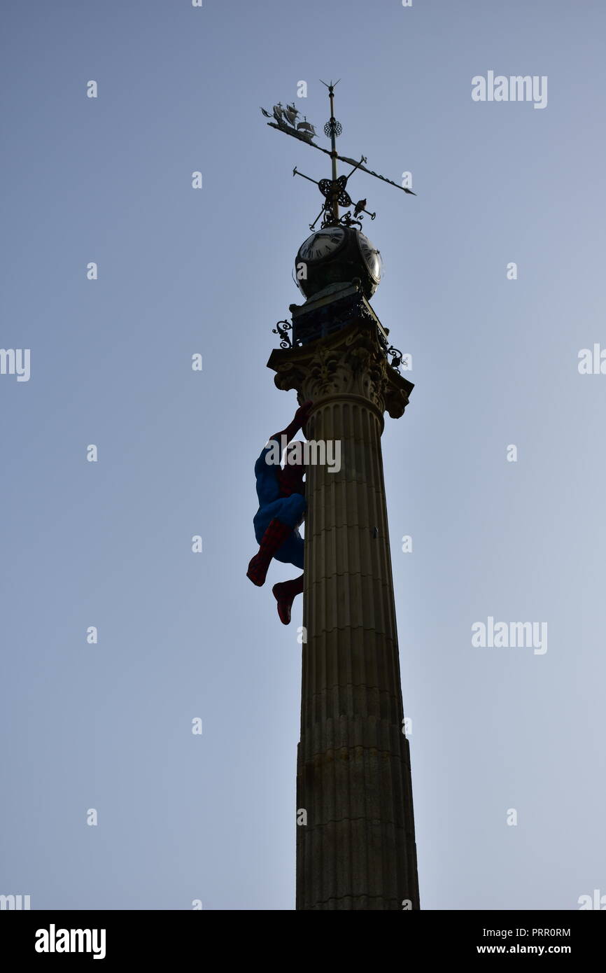 Spider-man Figur klettert einen Obelisk mit Uhr und Windfahne. A Coruña Comic-Con, Spanien. Stockfoto